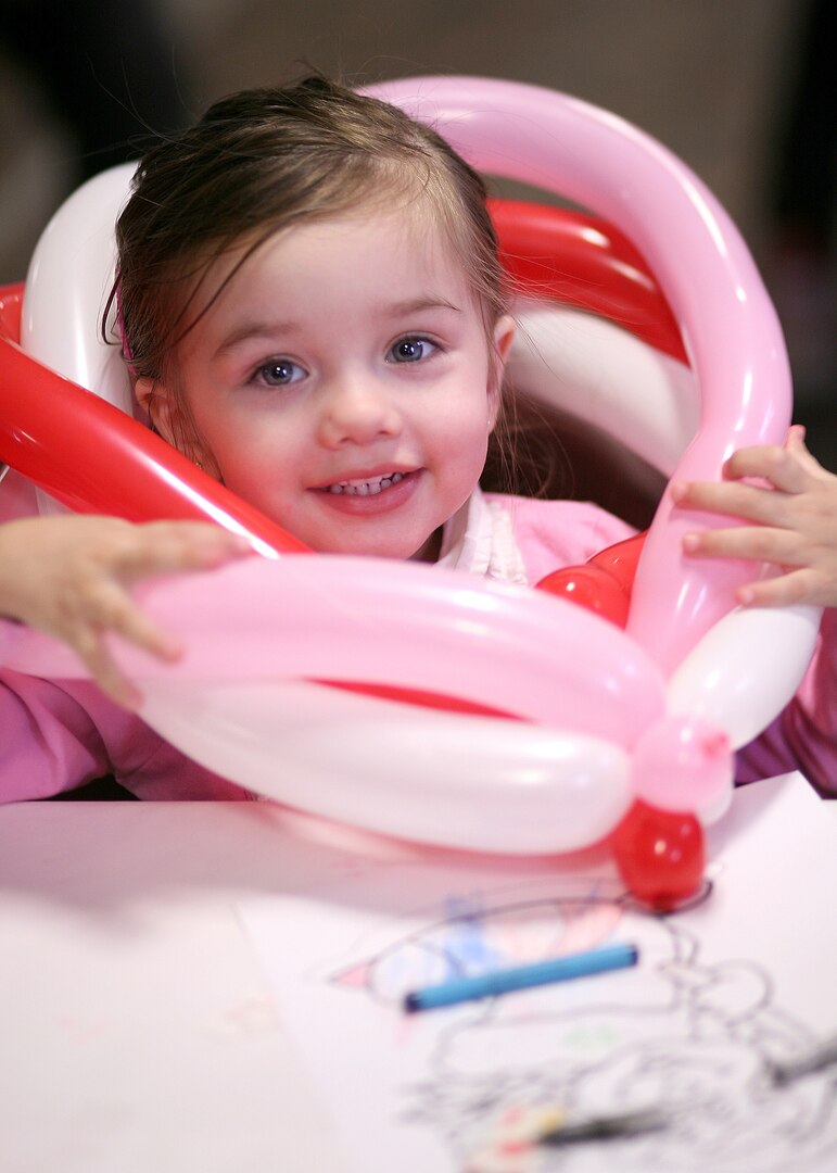 Abigail, daughter of Staff Sgt. Sue Hemgesberg, 59th Laboratory Squadron, plays with balloons during the children's holiday party Dec. 12. (U.S. Air Force photo/Robbin Cresswell) 