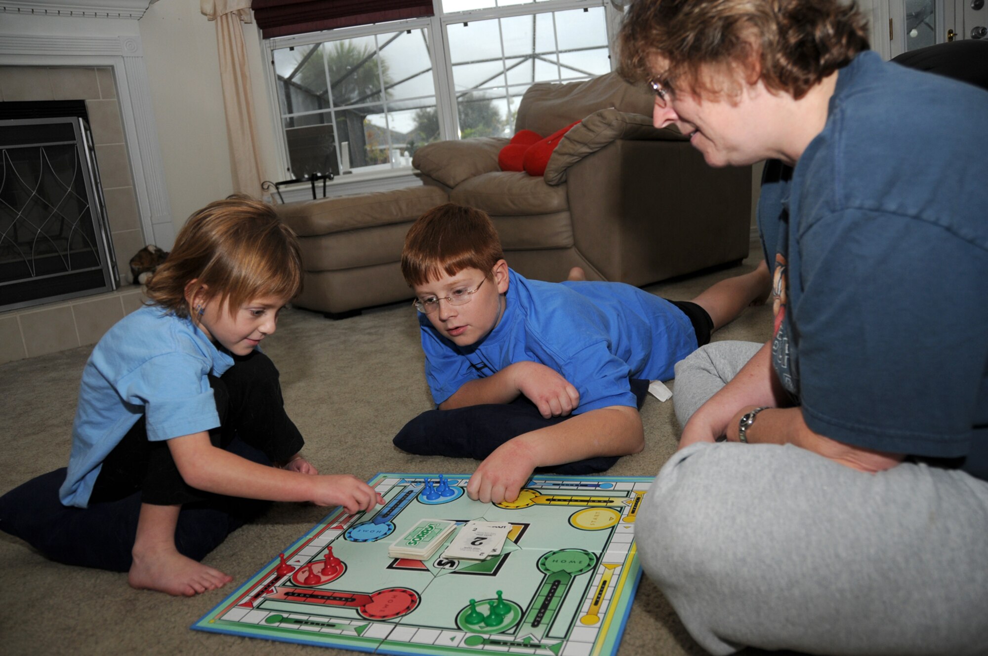 Amber, Austin and Lisa Hunte enjoy playing a board game together in their Woolmarket home.  (U.S. Air Force photo by Kemberly Groue)