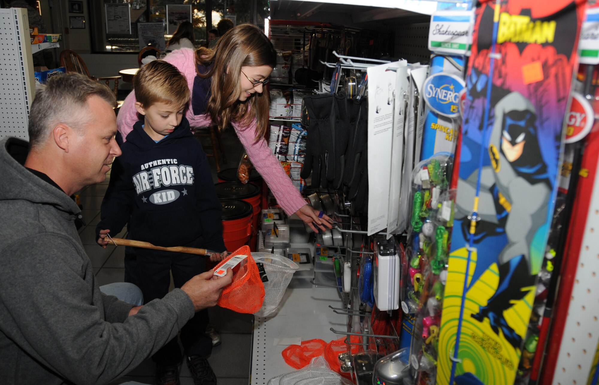 Thomas, Adam and Jordan Cimienski shop for fishing gear at the marina Dec. 10.  Fishing is one way they family spends its time while Erin Cimienski is deployed.  (U.S. Air Force photo by Kemberly Groue)