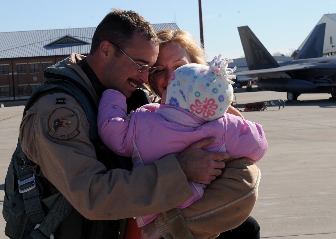 LANGLEY AIR FORCE BASE, Va.-- Capt. Matthew Howard, 27th Fighter Squadron pilot, and his wife Candie hold their daughter Trinity, 2, after Captain Howard returns from a deployment Dec. 16. The 27th FS deployed six aircraft in support of a 40-day training exercise in southwest Asia. (U.S. Air Force photo/Airman Rebecca Montez) (RELEASED)