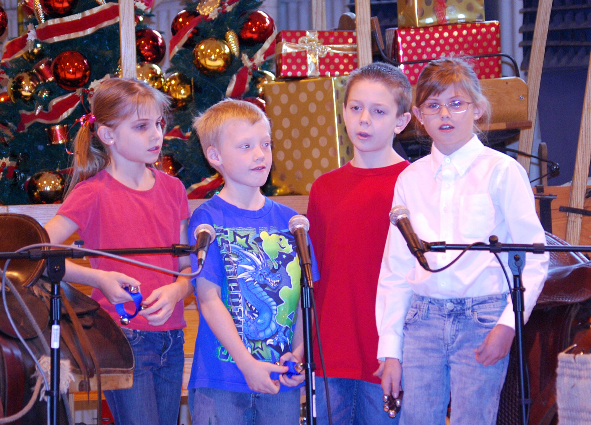 Children from the Vance School Age Program sing holiday songs during Brunch with Santa held Dec. 12 in Hangar 170. The children are Kasey (far left) and Kaitlin (far right) Colleary, daughters of Kristine Colleary with CSC Applied Technologies Human Resources; Nicholas Trembly (center left), son of Staff Sgt. Danielle Snider with the 71st Logistics Readiness Squadron Emergency Management; and Sam Keith (center right), son of Stormie Keith with CSC Aircraft Maintenance. (Photo by Ashley Murphy)