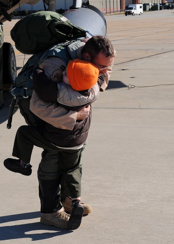 LANGLEY AIR FORCE BASE, Va. -- Capt. Matthew Howard, 27th Fighter Squadron pilot, hugs his son Chance, 4, after returning from a deployment Dec. 16. The 27th FS deployed six aircraft in support of a 40-day training exercise in southwest Asia. (U.S. Air Force photo/Airman Rebecca Montez) 