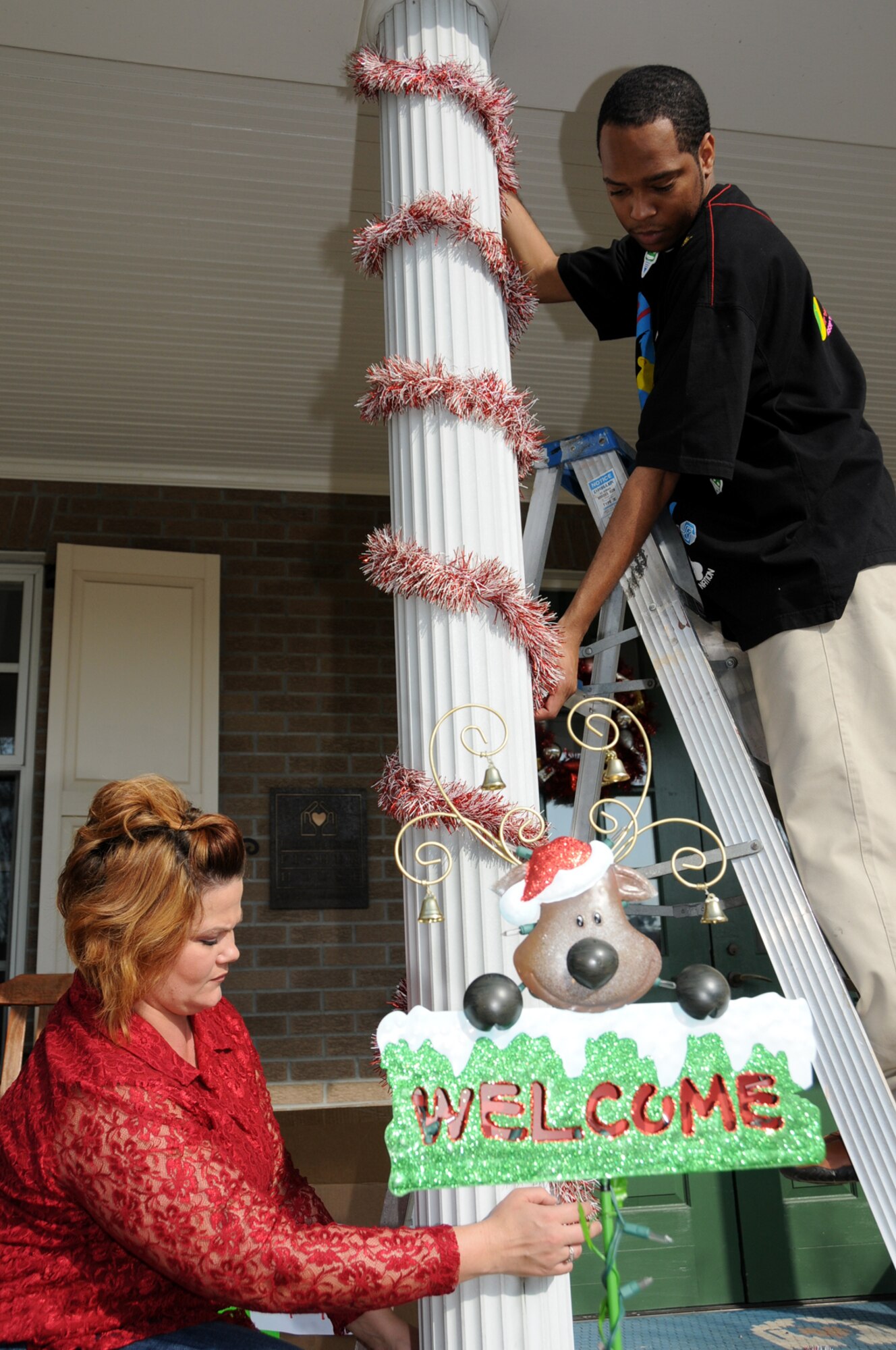 Team leaders Deighleen Judy, left, and C.J. Gillian adorn the columns on the front porch at Fisher House.  (U.S. Air Force photo by Kemberly Groue)