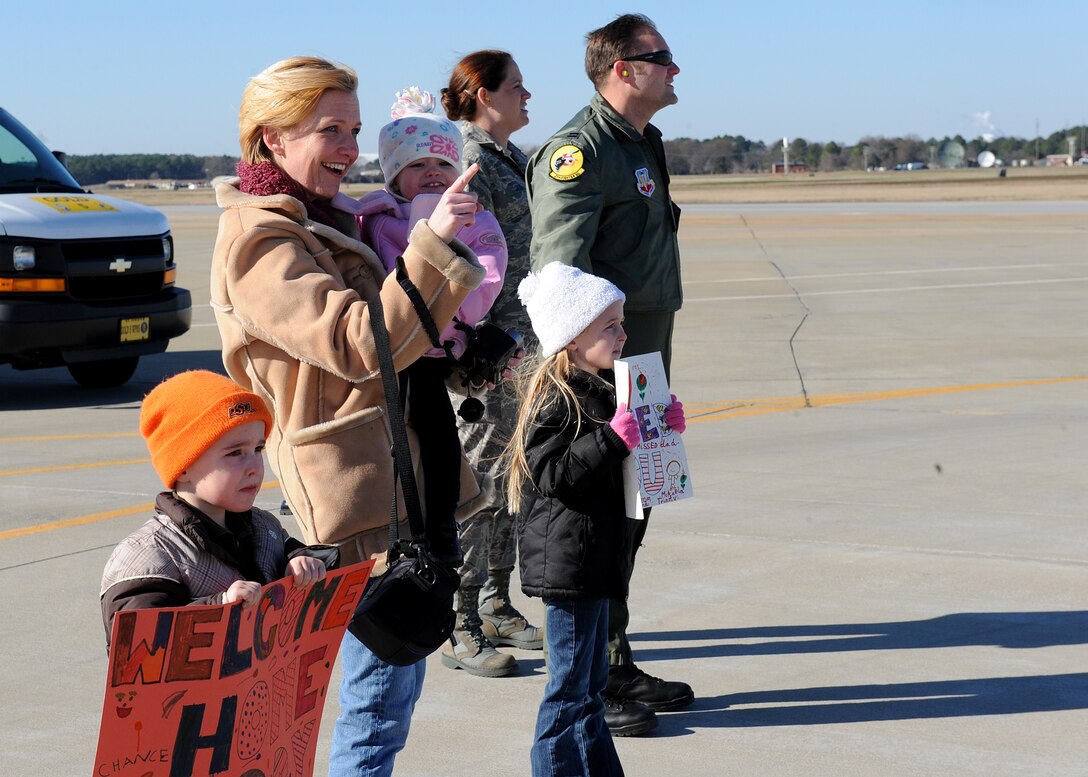 LANGLEY AIR FORCE BASE, Va. -- Candie Howard, wife of Capt. Matthew Howard, 27th Fighter Squadron pilot, and their children Mikaela, Chance, and Trinity, watch as Captain Howard returns from a deployment Dec. 16. The 27th FS deployed six aircraft in support of a 40-day training exercise in southwest Asia. (U.S. Air Force photo/Airman Rebecca Montez) 