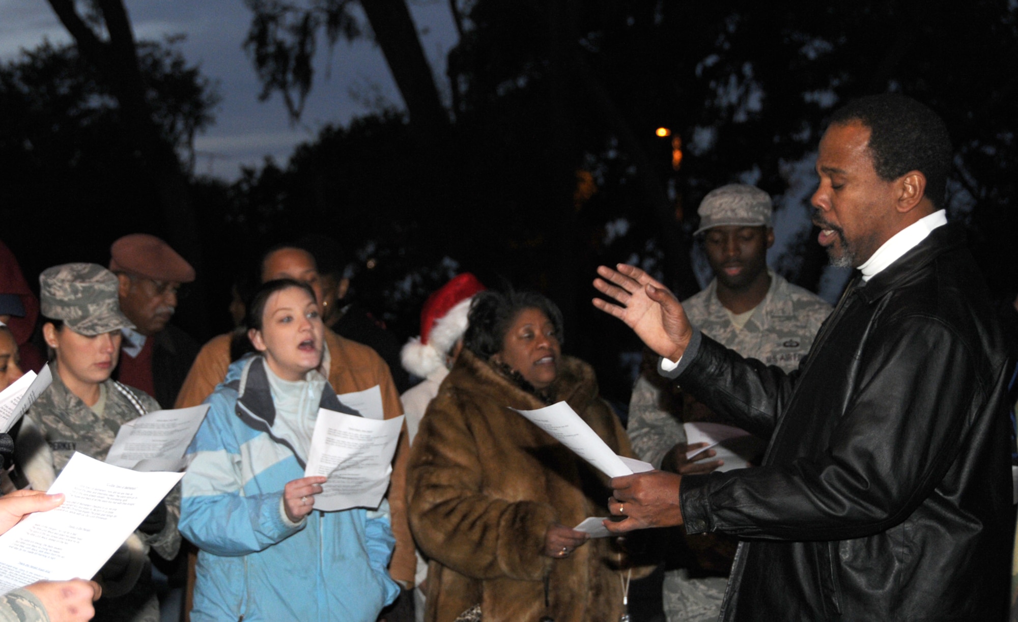 Keesler’s gospel service choir director Dennis Thompson leads a group of carolers during the live nativity scene at the annual Christmas in the Park celebration at marina park.  Nearly 2,000 people took part in the Dec. 10 event, which also included decorations, hay rides, toy giveaways, refreshments and a visit from Santa Claus.   (U.S. Air Force photo by Tech. Sgt. Charles Marsh)
