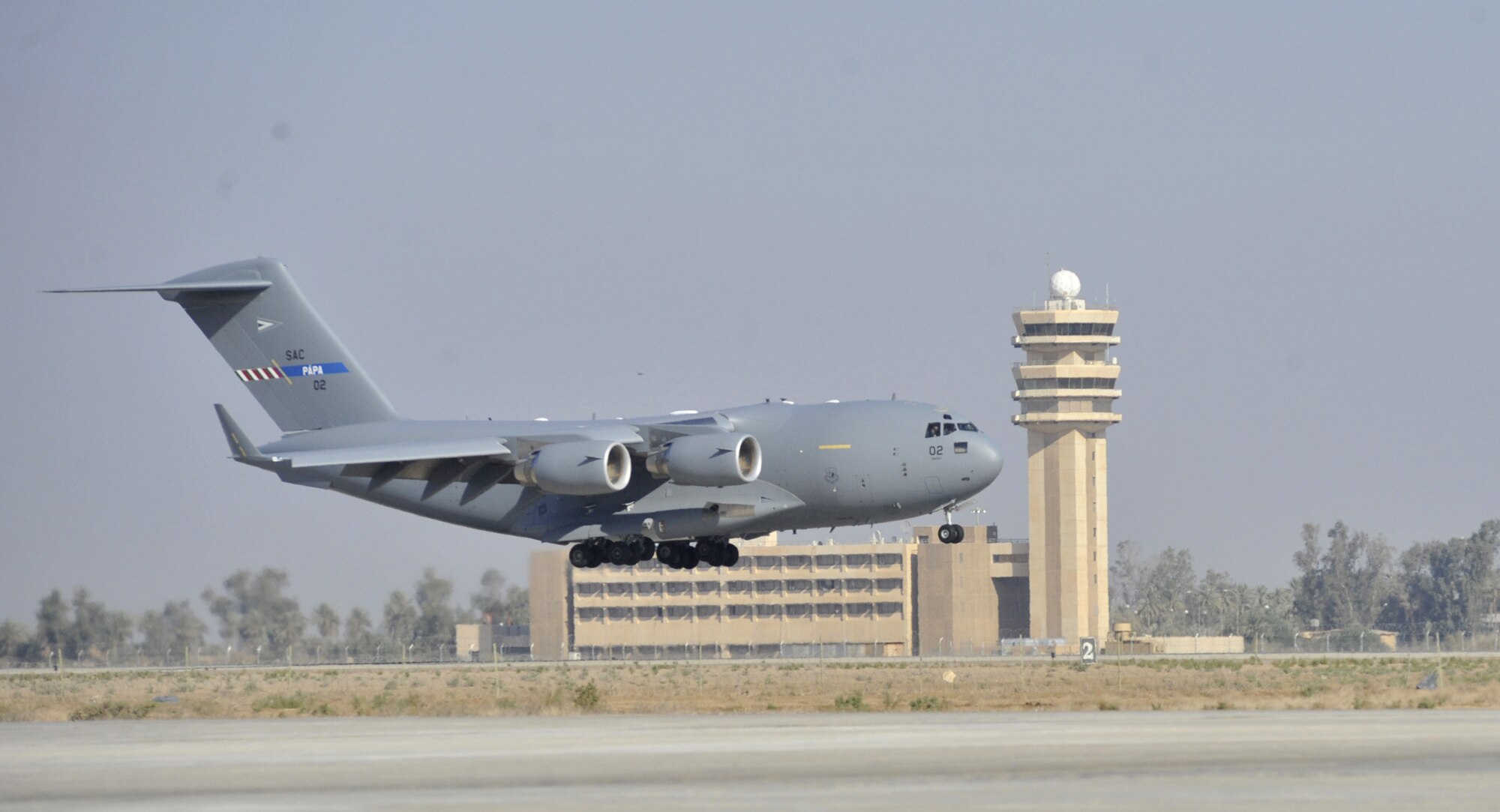 A C-17 Globemaster III from the multinational Heavy Airlift Wing based at Papa Air Base, Hungary, makes the new unit's first landing at Baghdad International Airport, Iraq. The airlift into Iraq was a first by the wing and facilitated the deployment for members of the NATO Training Mission-Iraq. The wing operates three C-17s and includes NATO member nations Bulgaria, Estonia, Hungary, Lithuania, the Netherlands, Norway, Poland, Romania, Slovenia and the U.S., as well as Partnership for Peace nations Finland and Sweden. (U.S. Air Force photo)
