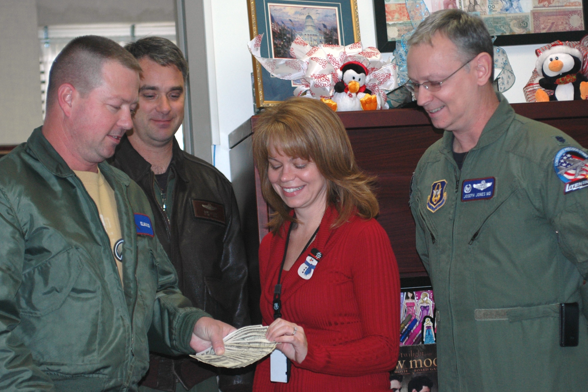 Rachell Wood, the 917th Wing’s point of contact for the Santas in Blues program on Barksdale Air Force Base, La., accepts a whopping donation of $1,363.93 from the 93rd Bomb Squadron here on Barksdale. Santas in Blues is a base-sponsored program designed to bring Christmas to underprivileged foster children in the Caddo, Bossier, Webster and De Soto parishes. Presenting the money, from left to right, is Senior Master Sgt. Darren Ellingwood, an operations intelligence specialist for the 917th Wing, Lt. Col. David Leedom, director of operations, 93rd BS and Lt. Col. Joseph Jones, commander, 93rd BS. The 917th Wing’s generosity brought the total amount collected to a surprising $6,243.03. The 717th Aircraft Maintenance Squadron at Barksdale followed closely behind the 93rd BS by raising $1,093 for the program.  (U.S. Air Force photo/Mrs. Betty Stephens)