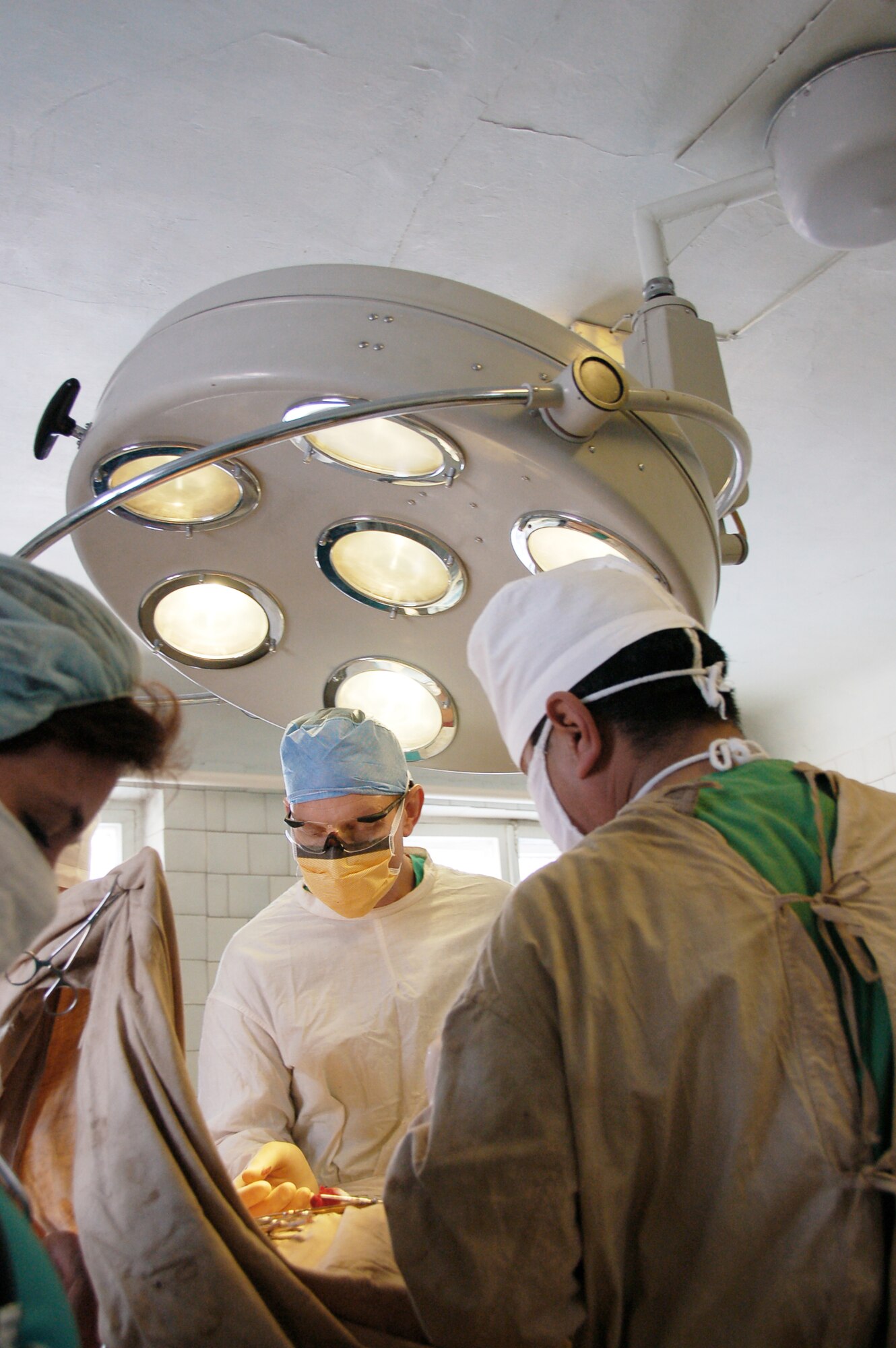 Lt. Col. (Dr.) Joseph Browne assists in performing a surgical operation with a Kyrgyz surgeon during a joint medical operation at a Kyrgyz Republic military hospital Dec. 11, 2009. A team of Airmen visited the hospital and performed two separate procedures. The joint operations were part of an ongoing partnership between medical Airmen at the Transit Center at Manas, Kyrgyzstan, and their counterparts at the Besh-Kungei Military Hospital. Doctor Browne is with the 376th Expeditionary Medical Group at the Transit Center at Manas. (U.S. Air Force photo/Staff Sgt. Olufemi Owolabi)