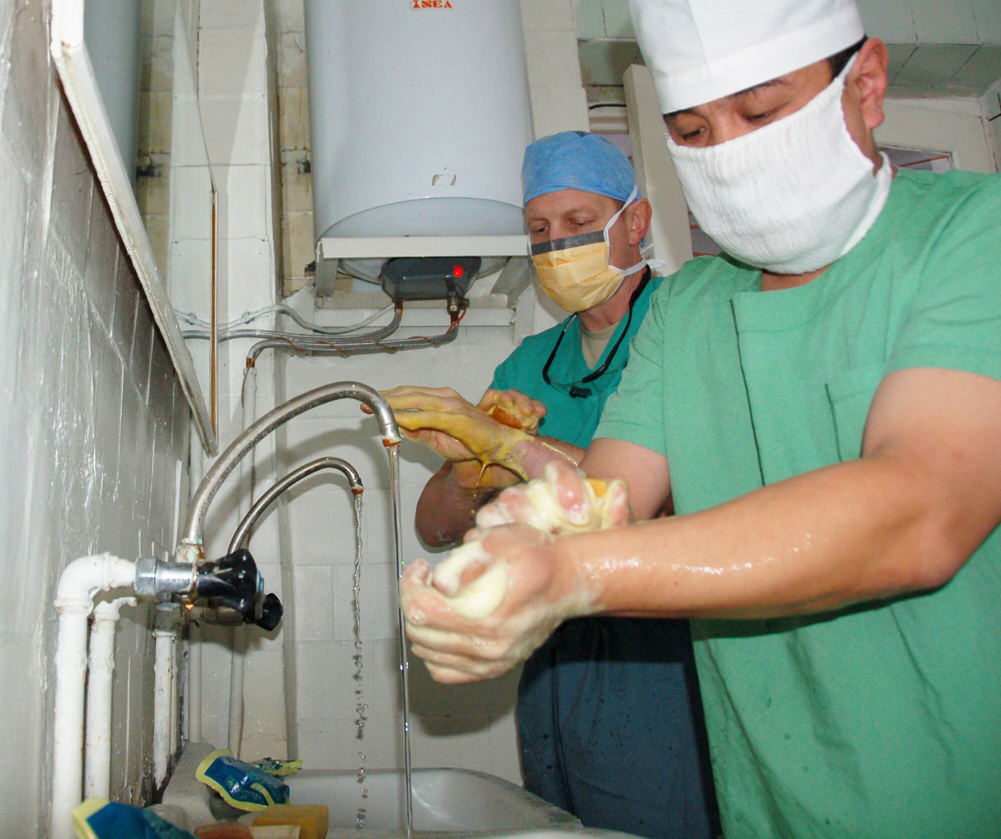 Lt. Col. (Dr.) Joseph Browne cleans up for a surgery alongside a Kyrgyz surgeon before a joint medical operation Dec. 11, 2009, in a military hospital in Kyrgyzstan. During their operation, Doctor Browne and the Kyrgyz doctor operated on a patient with broken collar bones. During the visit, the team of Airmen from the Transit Center at Manas, Kyrgyzstan, assisted their Kyrgyz counterparts with two surgical procedures. The team of Airmen was led by Col. (Dr.) Jerrold Flyer, 376th Expeditionary Medical Group commander. (U.S. Air Force photo/Staff Sgt. Olufemi Owolabi)
