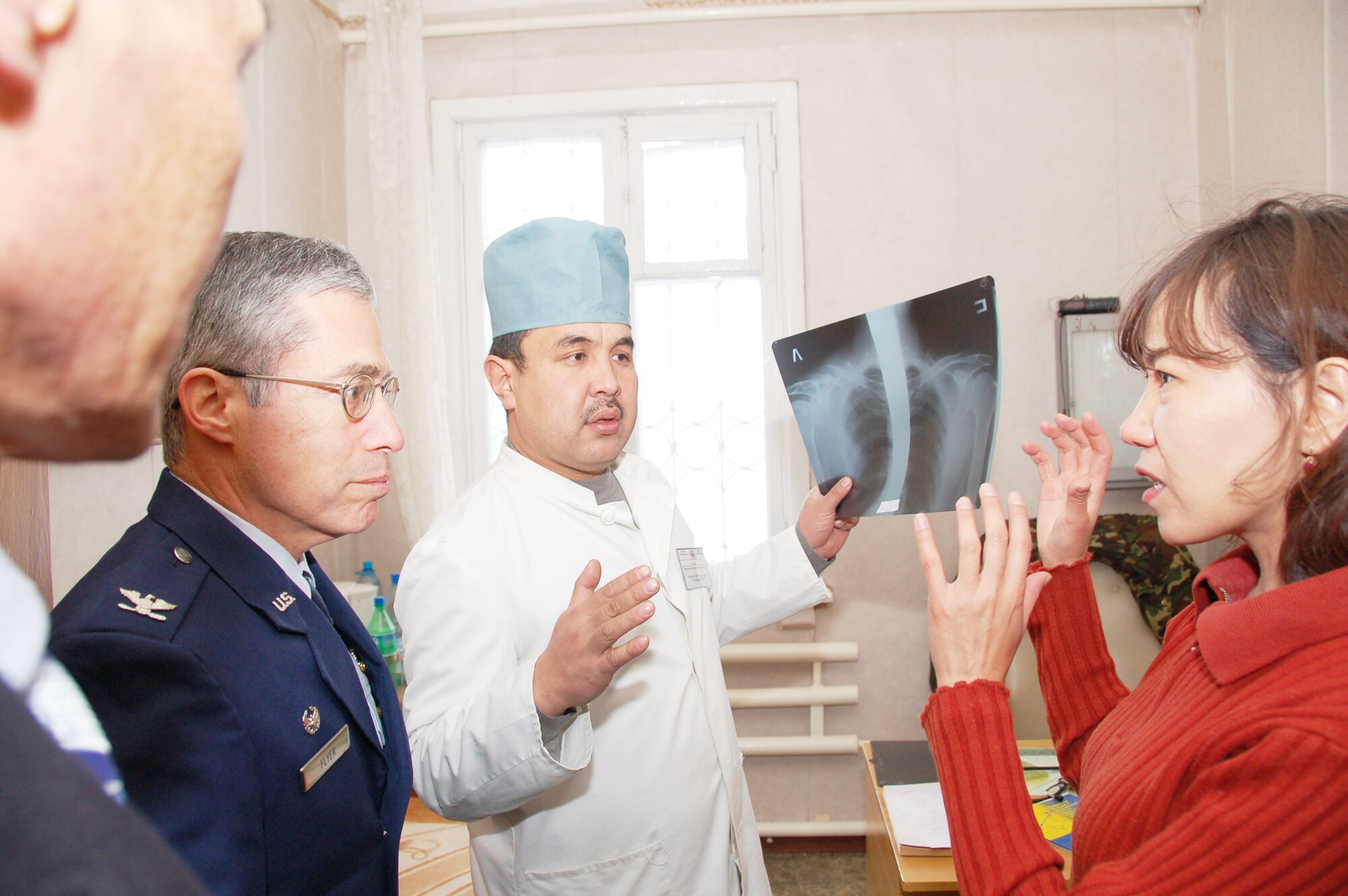 Col. (Dr.) Jerrold Flyer listens as Janyl Sabirova, translator, explains the type injury the colonel will be operating on during a joint surgery Dec. 11, 2009, between him and a Kyrgyz doctor at a Kyrgyz hospital. A team of Airmen from the Transit Center at Manas, Kyrgyzstan, visited the hospital and assisted the Kyrgyz in two separate surgical operations. The joint procedures were part of an ongoing partnership between medical Airmen at the Transit Center and their counterparts at the Besh-Kungei Military Hospital. Doctor Flyer is the 376th Expeditionary Medical Group commander. (U.S. Air Force photo/Staff Sgt. Olufemi Owolabi)
