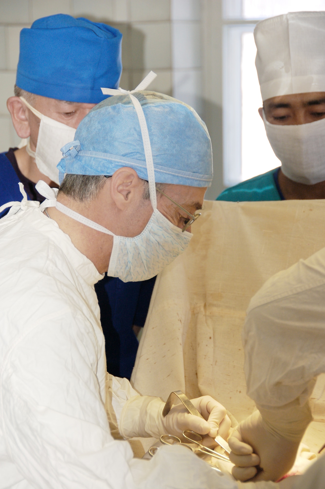 Col. (Dr.) Jerrold Flyer performs a surgery with a Kyrgyz surgeon during a joint medical operation at a Kyrgyz Republic military hospital in Kyrgyzstan Dec. 11, 2009. A team of Airmen visited the hospital and performed two separate surgical operations. The joint procedures were part of an ongoing partnership between medical Airmen at the Transit Center and their counterparts at the Besh-Kungei Hospital. Doctor Flyer is the commander of the 376th Expeditionary Medical Group at the Transit Center at Manas, Kyrgyzstan. (U.S. Air Force photo/Staff Sgt. Olufemi Owolabi)