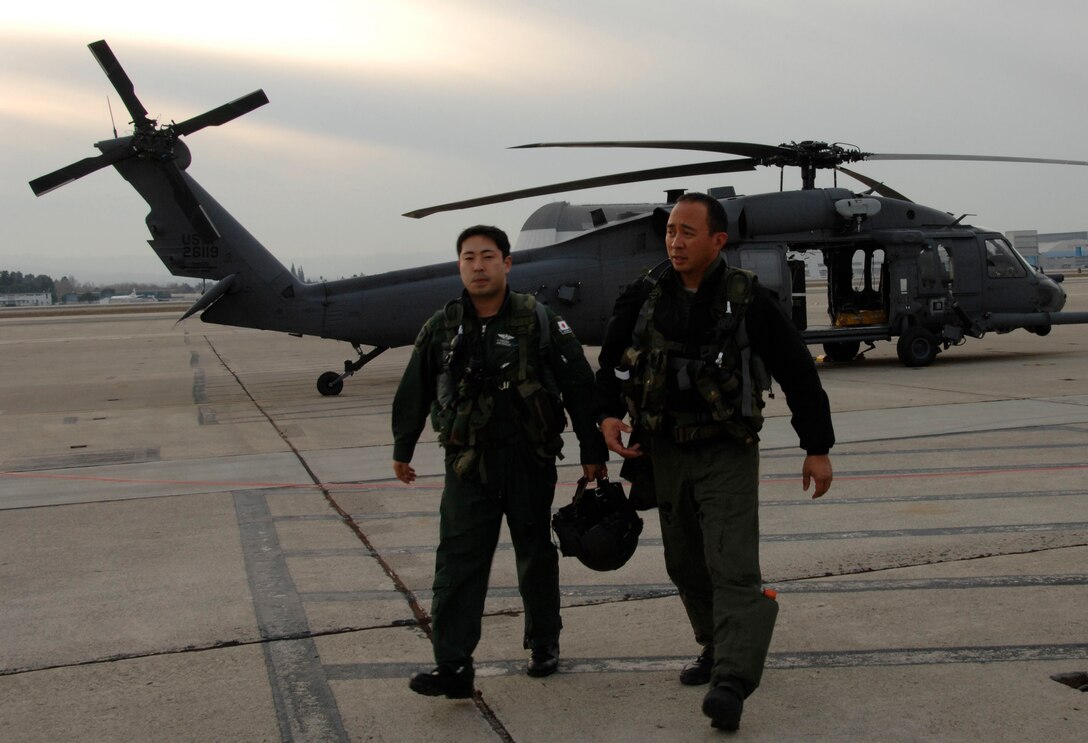 Maj. George Dona (right), an HH-60G Pave Hawk pilot with the 129th Rescue Squadron, Moffett Federal Airfield Calif., and Capt. Takeshi Tokuda (left), a Japan Air Self-Defense Force UH-60J pilot with the Air Rescue Wing at Komaki Air Base, Japan, head back to an operations building after a day of air refueling training Dec. 9, 2009. (Air National Guard photo by Tech. Sgt. Ray Aquino)