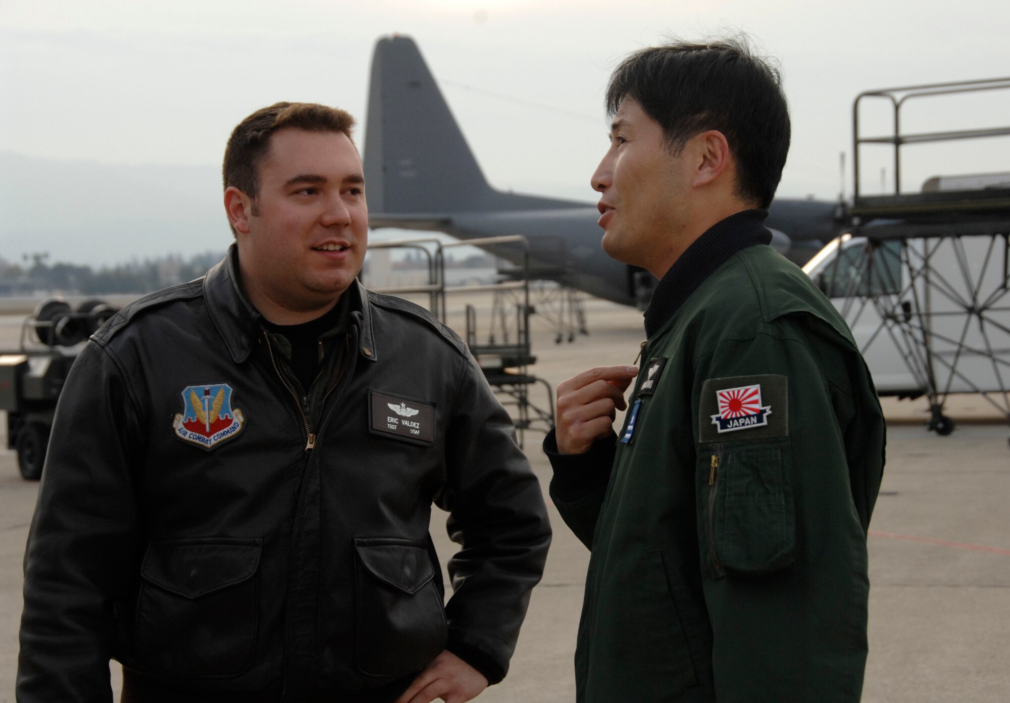 Maj. Masahiko Miyazaki, a Japan Air Self-Defense Force C-130H Hercules pilot with the 1st Tactical Airlift Wing at Komaki Air Base, Japan, speaks with Tech. Sgt. Eric Valdez, an aircraft loadmaster with the 130th Rescue Squadron, Moffett Federal Airfield Calif., about their air refueling training Dec. 9, 2009. (Air National Guard photo by Tech. Sgt. Ray Aquino) 