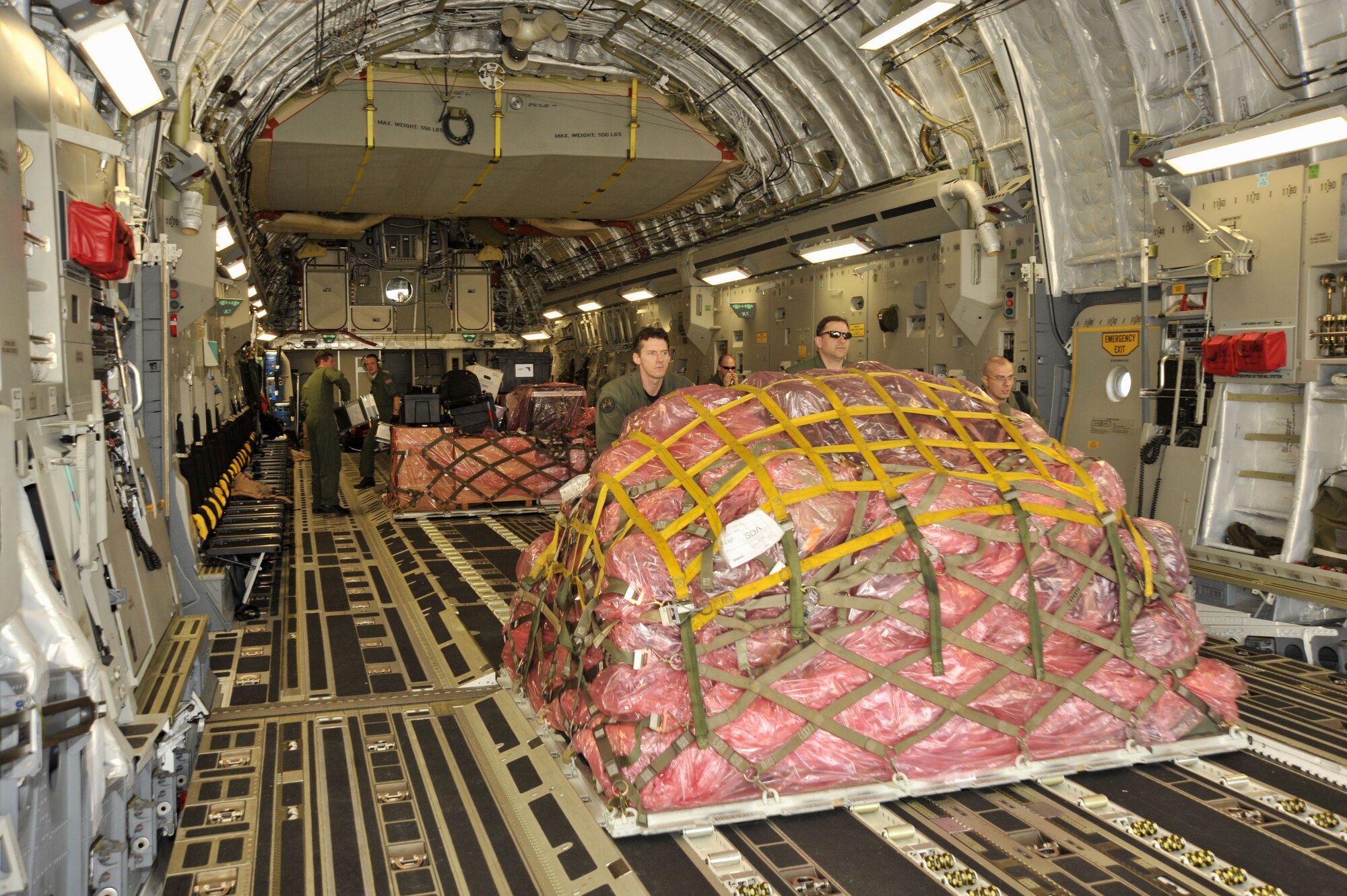 Airmen from the multinational Heavy Airlift Wing based at Papa Air Base, Hungary  unload a C-17 at Baghdad International Airport. The airlift into Iraq was a first by the wing comprised of 12 member nations and facilitated the deployment for members of the NATO Training Mission-Iraq. The wing operates three C-17s and includes NATO member nations Bulgaria, Estonia, Hungary, Lithuania, the Netherlands, Norway, Poland, Romania, Slovenia and the U.S., as well as Partnership for Peace nations Finland and Sweden.