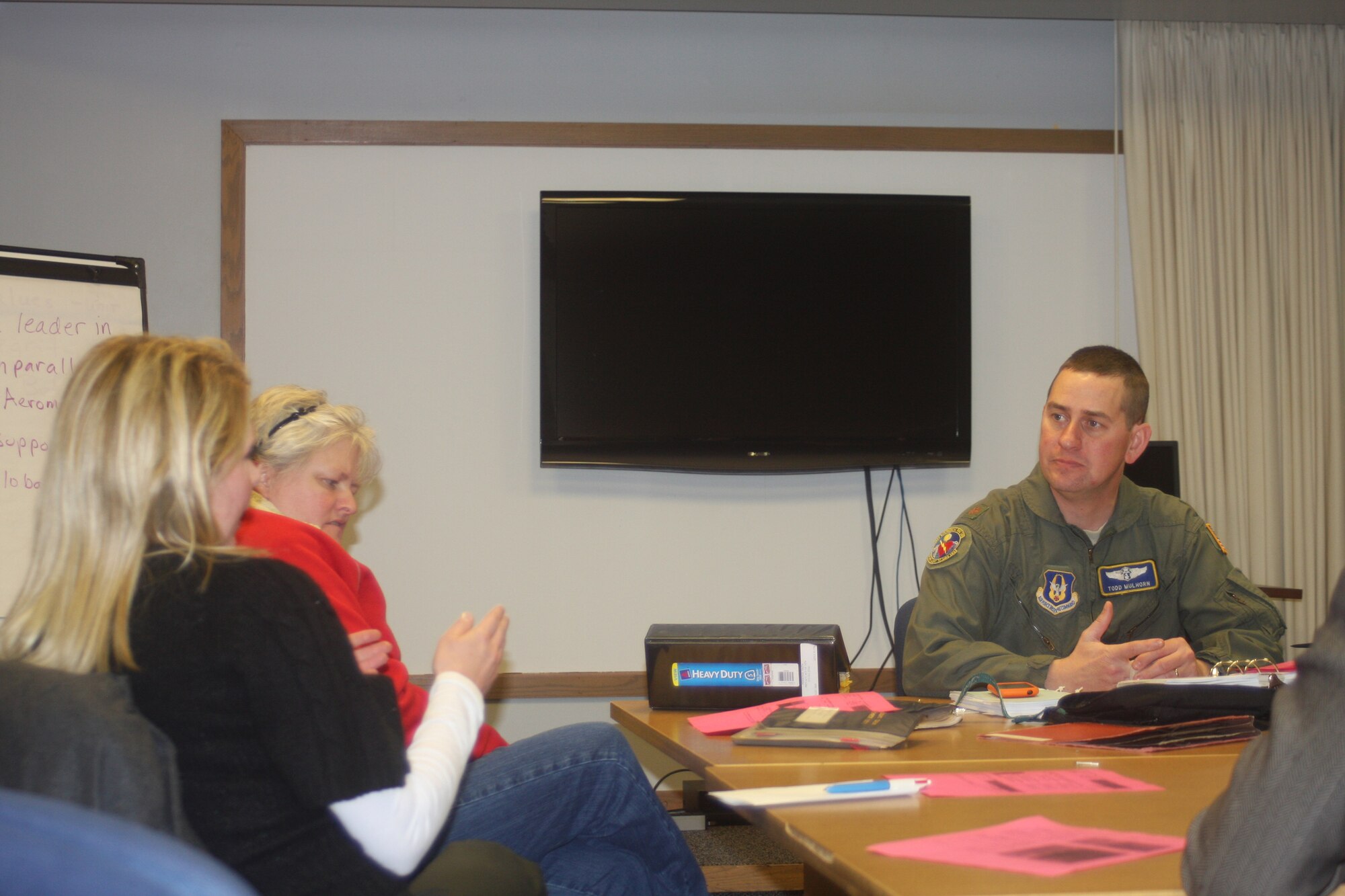 WRIGHT-PATTERSON AIR FORCE BASE, Ohio – Jill Treece asks Maj. Todd Mulhorn, 445th Aeromedical Evacuation Squadron operations officer, a question about the AES training program as Lynda Jayjohn listens in. Seven staff members from The Ohio State University Medical Center Perioperative Services spent the afternoon Dec. 2 at the 445th AES to learn about their training program and see if it’s a program they can mirror in their work environment. The group is looking at applying principals of aircrew operations, checklist discipline, training, and evaluation to the operating room environment. (U.S. Air Force photo/Stacy Vaughn)