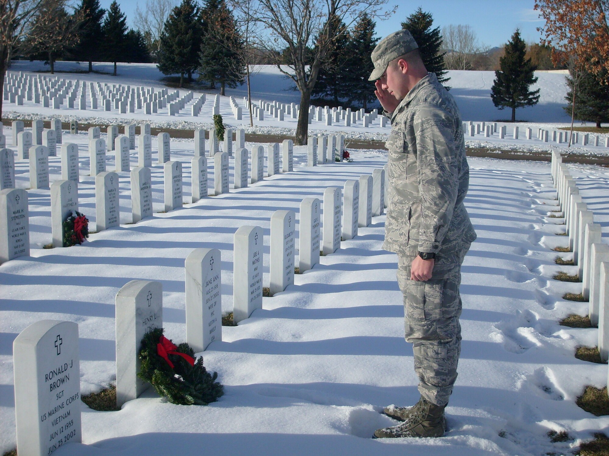 1st Lt. Brandon Goebel places a wreath on the grave of Navy Seaman Apprentice Henry L. Long. Seaman Long's family requested Lieutenant Goebel visit the grave during Wreaths Across America and place a wreath. (Photo courtesy of U.S. Air Force Master Sgt. Timothy O'Connor)