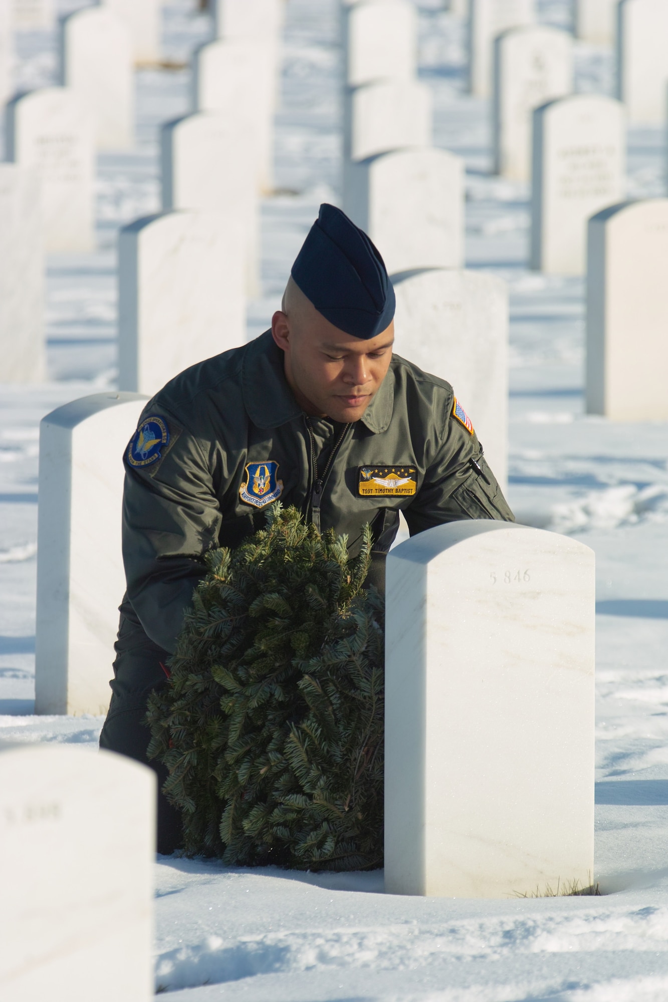 Tech. Sgt. Timothy Baptist from Schriever Air Force Base, Colo., lays a wreath on a veteran's grave during Wreaths Across America. Volunteers laid more than 400 wreaths during the Dec. 12 event. (U.S. Air Force photo by Master Sgt. Steven Clark)