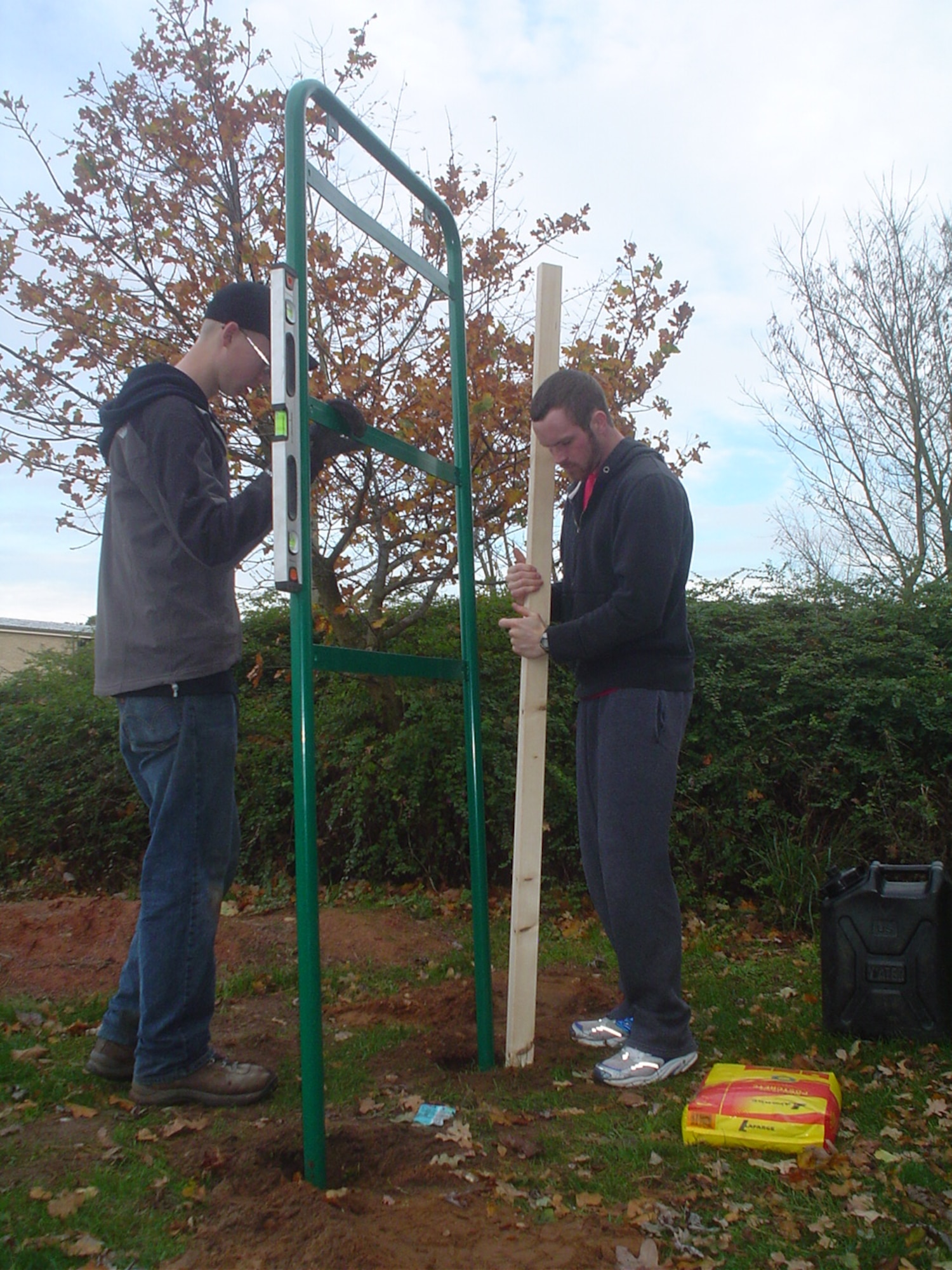 Joshua Kent (left) and Mick McNaughton position the poles of one of the 15 new fitness stations along the RAF Lakenheath running trail.  Joshua Kent, a boy scout with Troop 219 here, initiated this project to earn his Eagle Scout badge. (U. S. Air Force photo/Capt. Alysia Harvey) 