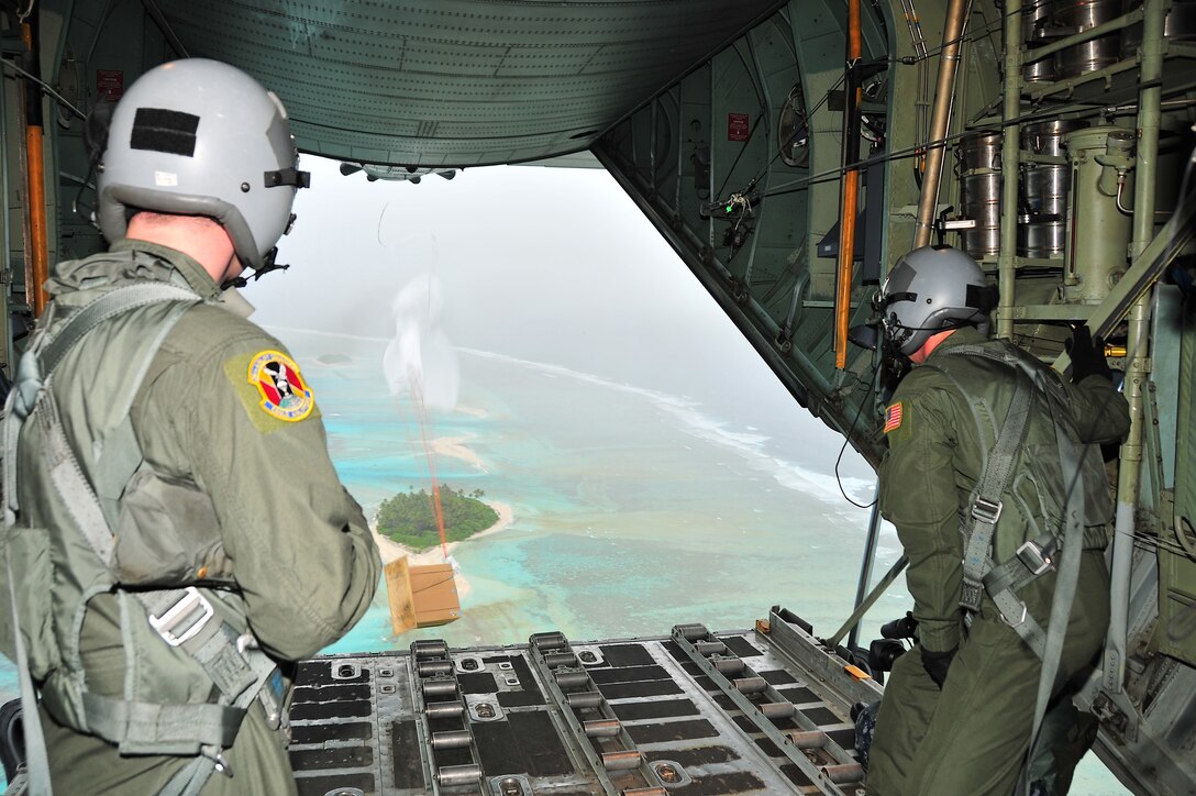 CHUUK, Commonwealth of the Northern Marianas Islands -- Members of the 36th Airlift Squadron watch a bundle of donated goods drop out the back of a C-130 Hercules over a Chuuk island during Operation Christmas Drop Dec. 16. Operation Christmas Drop, the longest running humanitarian airlift mission in the world, delivers supplies to remore islands of the Commonwealth of the Northern Marianas Islands of Yap, Palau, Chuuk and Pohnpei. (U.S. Air Force photo/Tech. Sgt. Kimberly Spinner)