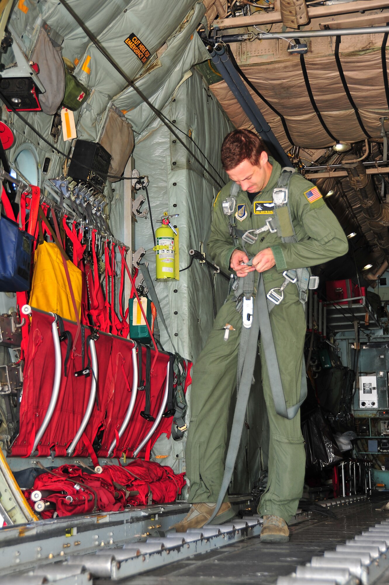 CHUUK, Commonwealth of the Northern Marianas Islands -- Senior Airman Dustin DeVeaux, 36th Airlift Squadron load master, adjusts his harness in preparation for the first day of Operation Christmas Drop Dec. 16. Operation Christmas Drop, the longest running humanitarian airlift mission in the world, delivers supplies to remote islands of the Commonwealth of the Northern Marianas Islands of Yap, Palau, Chuuk and Pohnpei. (U.S. Air Force photo/Tech. Sgt. Kimberly Spinner)