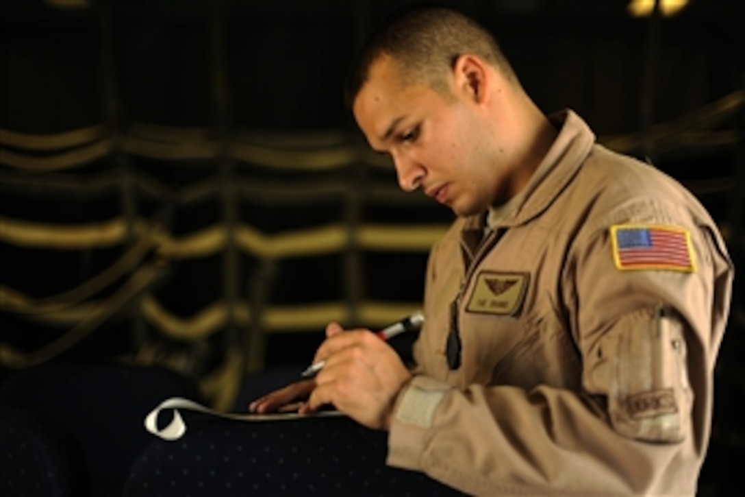 U.S. Air Force Senior Airman Johann Karpf, a KC-10A Extender boom operator with the 908th Expeditionary Air Refueling Squadron, calculates fuel weights during a mission to Afghanistan on Dec. 9, 2009.  