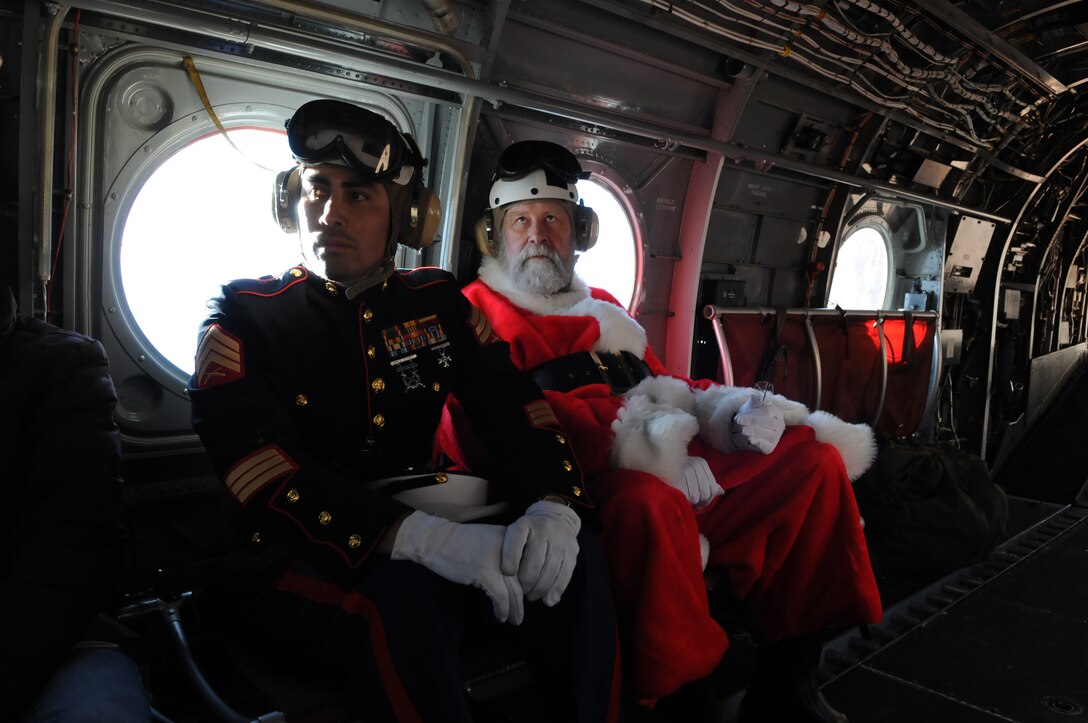 Santa Claus, portrayed by event coordinator Dick McCallum, rides alongside Sgt. Daniel M. Iversen in a CH-46 helicopter en route to the remote village of the Havasupai tribe in order to deliver Christmas gifts to children as part of the Toys for Tots program on Dec. 16, 2009. Iversen, a 31-year-old native of Torrance, Calif., was one of seven Marine reservists from the Phoenix-based Environmental Services Detachment who escorted Santa. Marine Medium Helicopter Squadron 764, a reserve unit based at Edwards Air Force Base north of Los Angeles, has flown toys to the village's children for Christmas as part of the Toys for Tots program for the past 14 years.