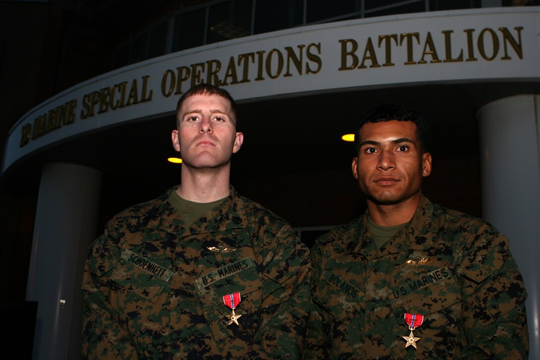 (From left to right) Staff Sgt. Samuel E. Schoenheit and Sgt. Carlos Bolanos stand in front of the 2nd Marine Special Operation's Headquarters building, Dec. 17, 2009. The Marines each received a Bronze Stars Medal with combat distinguishing device for their heroic actions in Afghanistan June 26, 2008.