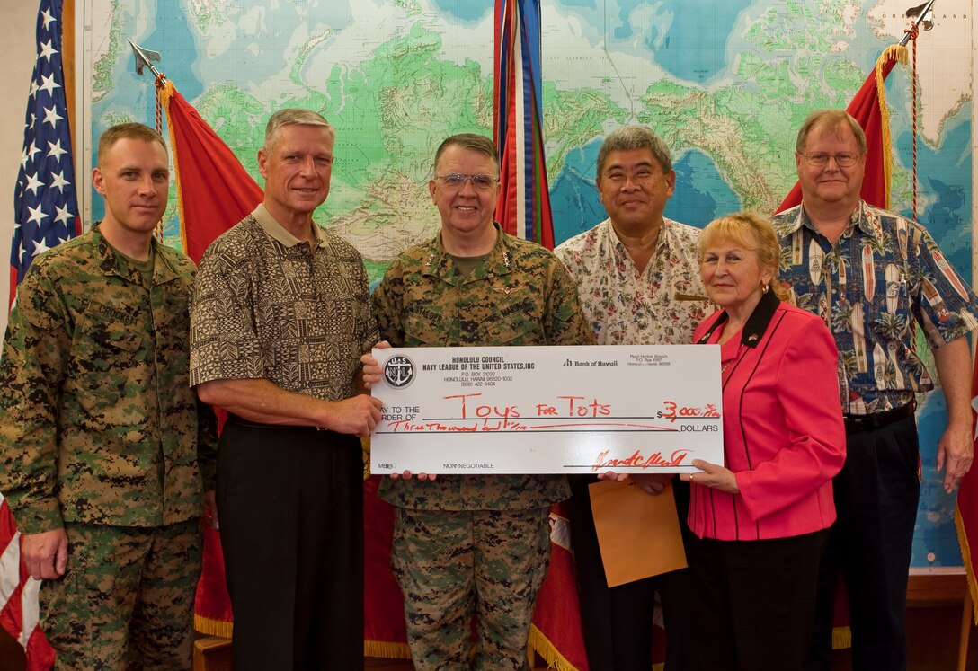 Representatives from the Honolulu Council of the Navy League present a $3,000 check to U.S. Marine Corps Forces, Pacific Commander Lt. Gen. Keith J. Stalder, center, for the Marine Corps Reserve's Toys for Tots program Dec. 17.   The check represents proceeds from the Navy League's annual Toys for Tots Golf Tournament.  (Official USMC Photo by Cpl. Cristina Noelia Gil) (Released)