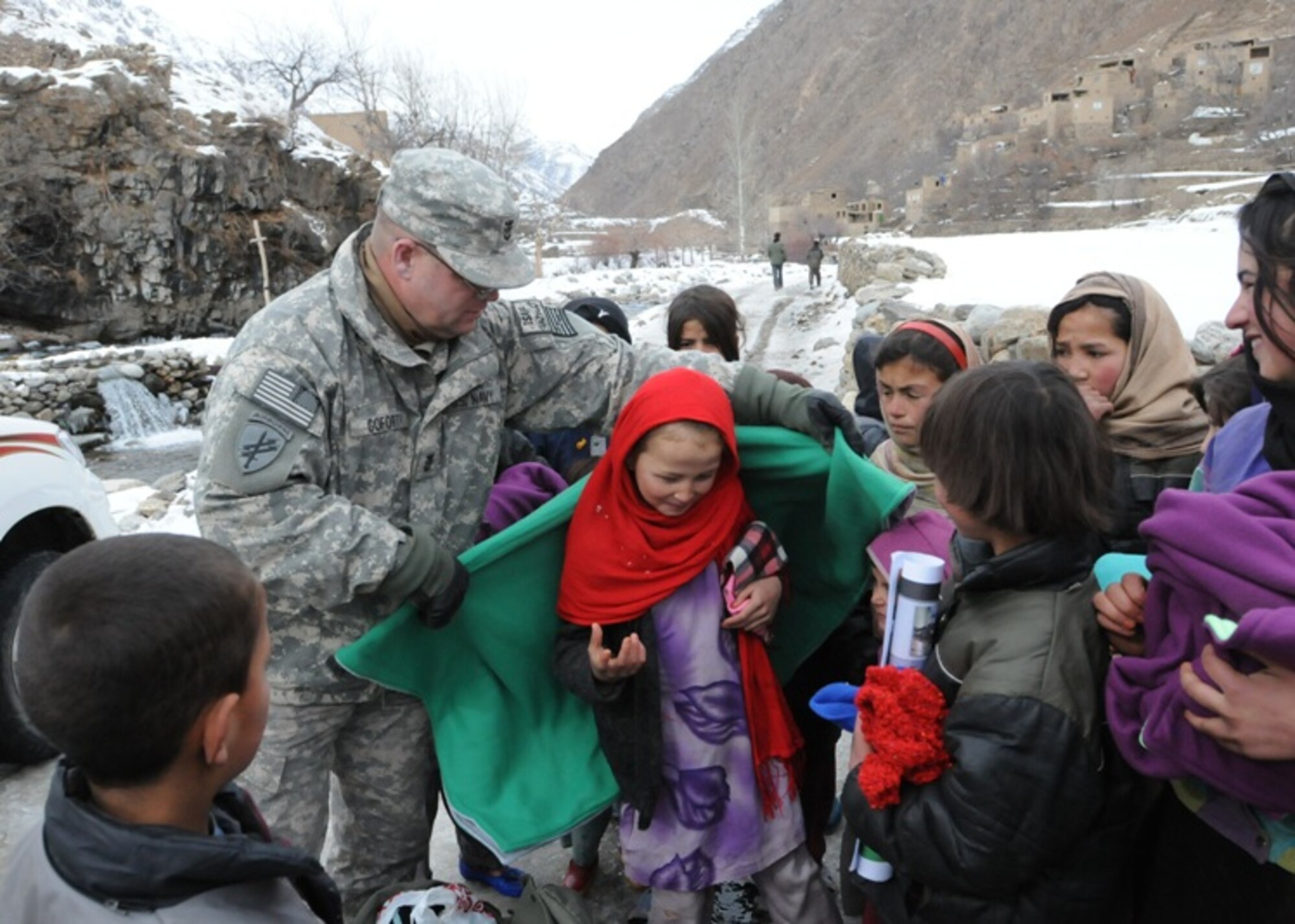 PANJSHIR PROVINCE, Afghanistan – Navy Master Chief Petty Officer William Goforth, Panjshir Provincial Reconstruction Team Civil Affairs, wraps a young resident of Panjshir’s Dara district in a hand-made quilt, in Afghanistan, Dec. 14. The quilts were made and donated by the “Lake Norman Piece-makers,” Lake Norman, N.C., and the “Afghans for Afghanistan” organization of the First Presbyterian Church of Aiken, S.C.  (Air Force photo/Capt. John T. Stamm)