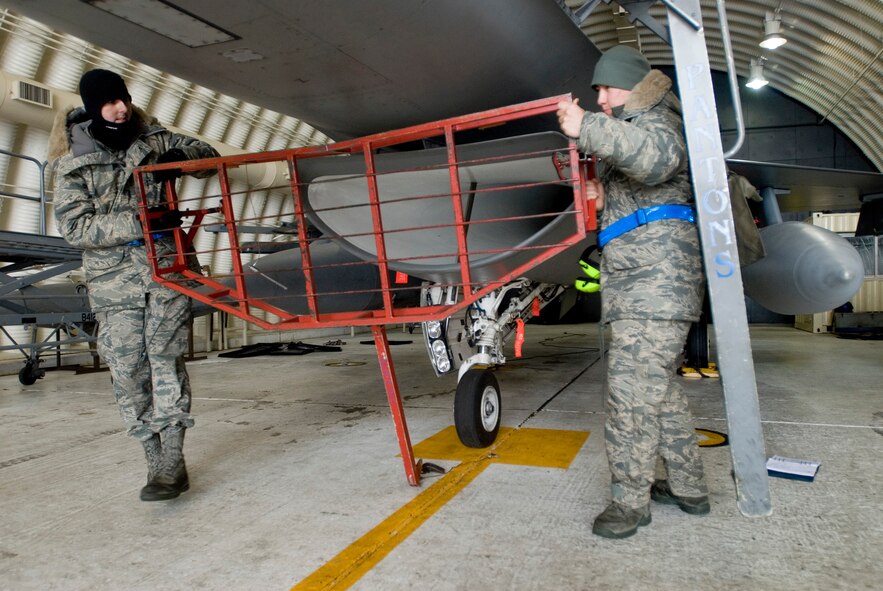 KUNSAN AIR BASE, Republic of Korea? Staff Sgt. Craig Huff and Senior Airman Gregory Nowak, 35th Aircraft Maintenance Unit, removes a run screen from an F-16 Dec. 18. Sgt. Huff and Airman Nowak were buttoning up the F-16 after performing engine check. (U.S. Air Force photo by Senior Airman Jonathan Steffen)
