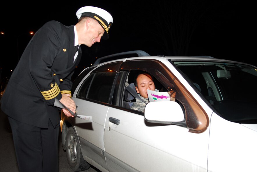 MISAWA CITY, Japan – Navy Capt. James Haugen, Naval Air Facility Misawa commanding officer, hands out traffic safety flyers Dec. 17, urging motorists to drive safely during the winter.  In addition to flyers, motorists were given a key chain as a reminder to drive safely. (U.S. Air Force photo/Staff Sgt. Phillip Butterfield)  