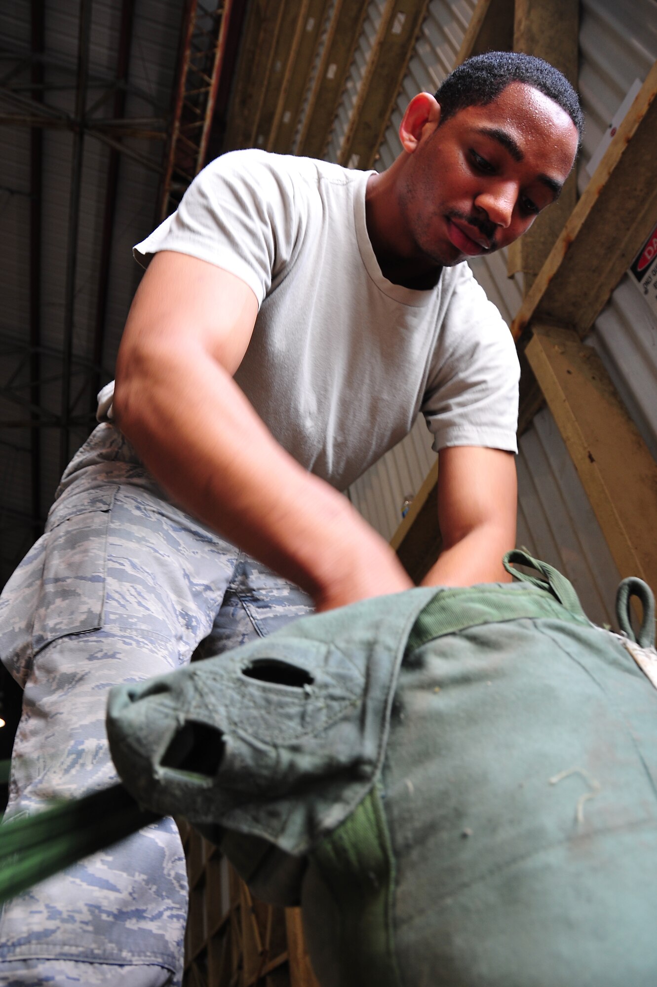 ANDERSEN AIR FORCE BASE, Guam ? SrA Eel Peterkin, 374th Logistics Readiness Squadron Senior Rigger, packs a chute in support of Operation Christmas Drop Dec. 18. The Combat Mobility Flight personnel rigged 57 bundles to support 12 sorties, to 51 islands covering a geographic area of more than 1.8 million square miles. (U.S. Air Force photo/Tech. Sgt. Kimberly Spinner)
