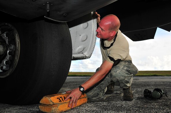 ANDERSEN AIR FORCE BASE, Guam -- Tech. Sgt. Harper Douglas, 374th Maintenance Squadron crew chief, inspects a tire for wear on a C-130 Hercules in support of Operation Christmas Drop Dec. 18. Operation Christmas Drop, the longest running humanitarian airlift mission in the world, delivers supplies to remote islands of the Commonwealth of the Northern Marianas Islands of Yap, Palau, Chuuk and Pohnpei. (U.S. Air Force photo/Tech. Sgt. Kimberly Spinner)