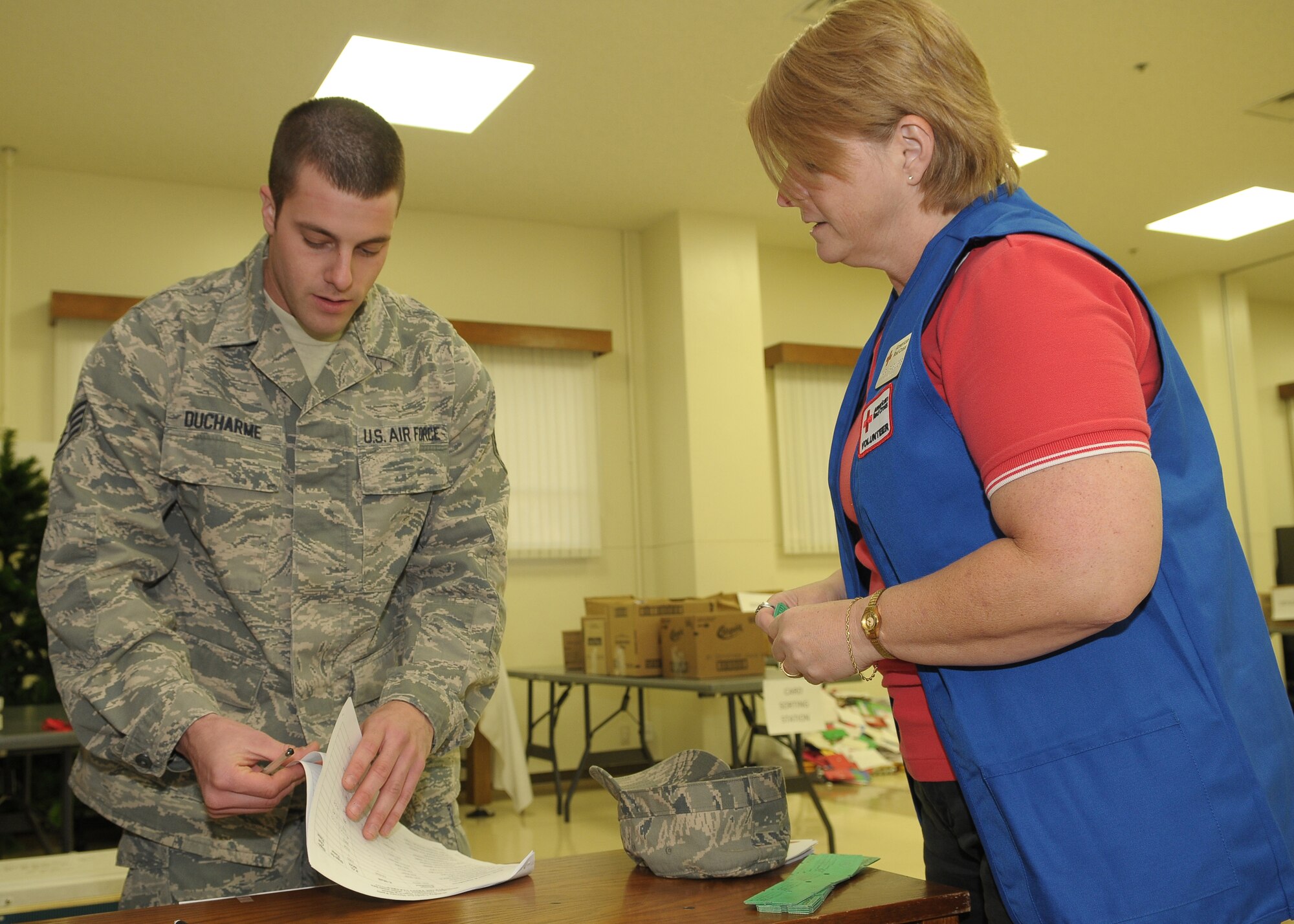 YOKOTA AIR BASE, Japan -- Staff Sgt. Robert Ducharme, 730th Air Mobility Squadron, signs in Dec. 17 to help out during the "Holiday Mail for Heroes" campaign. The Yokota Chapter of the American Red Cross received more than 15,000 holiday cards eventually delivered to military members at Yokota and downrange. (U.S. Air Force photo/Airman 1st Class Sean Martin)