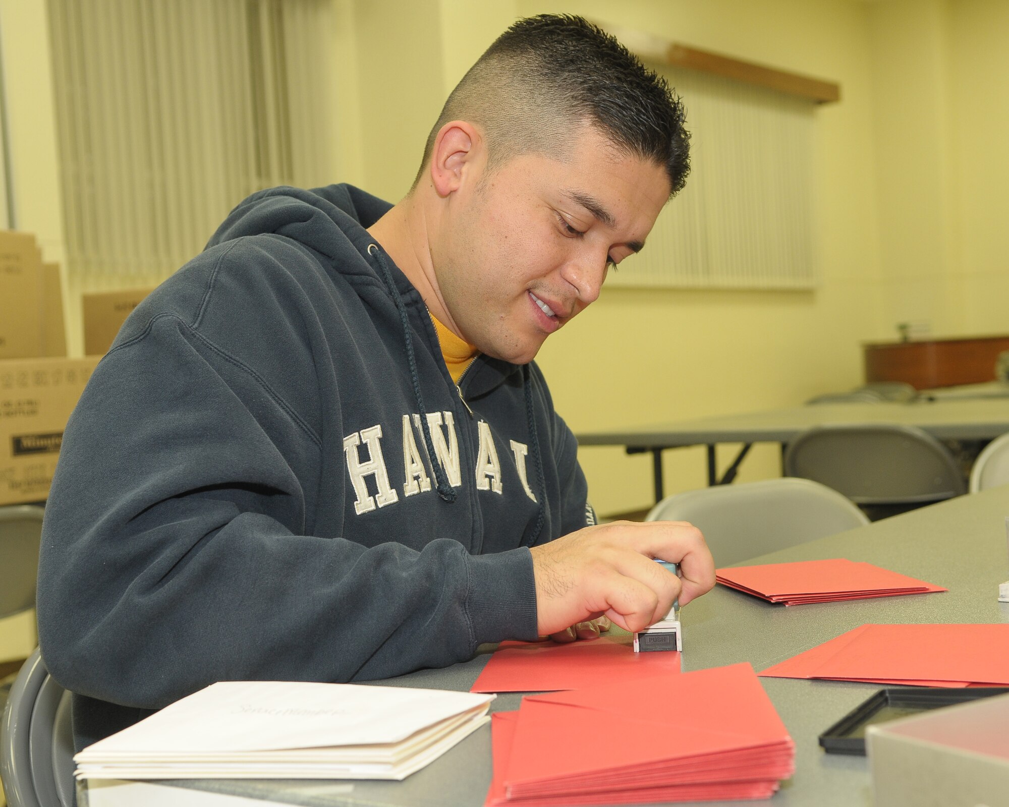 YOKOTA AIR BASE, Japan -- Staff Sgt. Jose Aguilar, 374th Operations Support Squadron, stamps a holiday card Dec. 17 during the "Holiday Mail for Heroes" campaign. The Yokota Chapter of the American Red Cross received more than 15,000 holiday cards eventually delivered to military members at Yokota and downrange. (U.S. Air Force photo/Airman 1st Class Sean Martin)