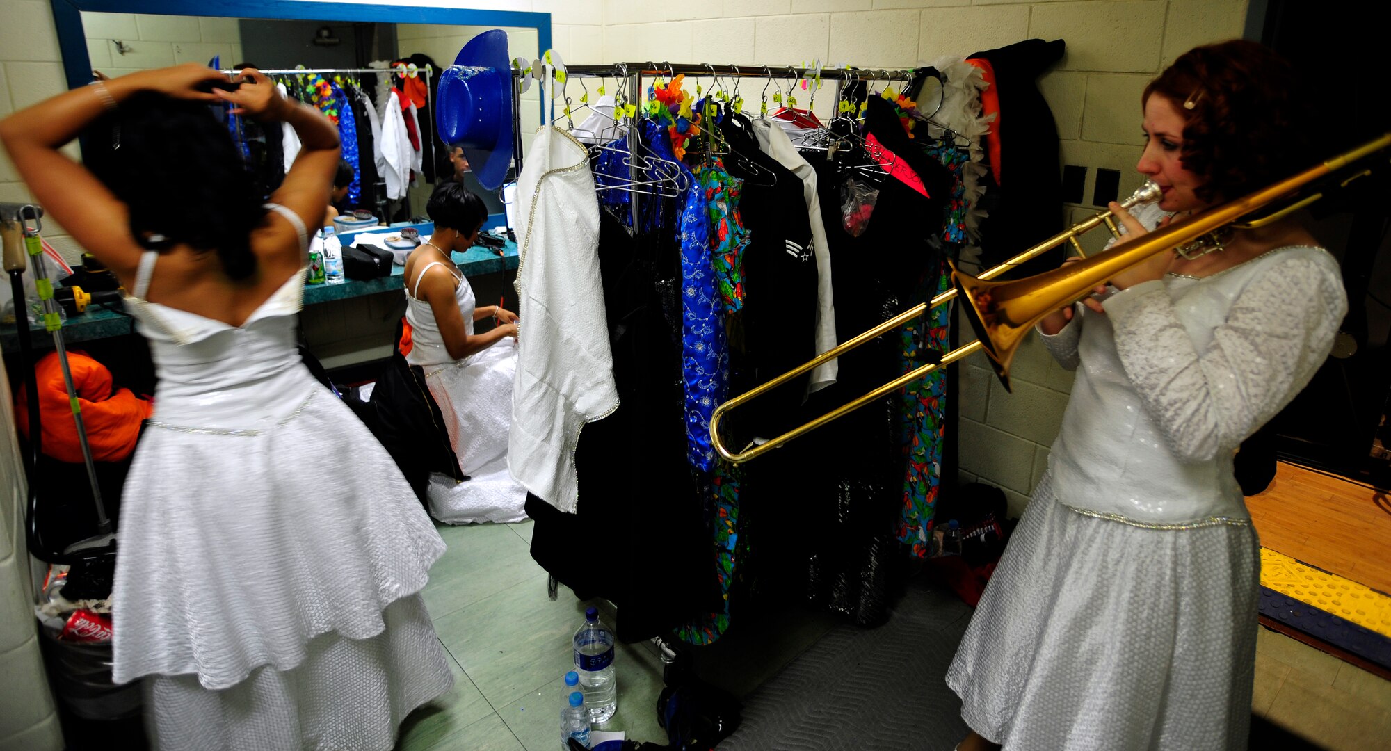 Senior Airman Victoria Howard practices on her trombone as Senior Airman
Christy Henderson, left, and Staff Sgt. Aisha Smith finish last-minute hair
and makeup before going on stage to perform for a standing room only
audience at Osan Air Base, Republic of Korea, Dec. 17.  (U.S. Air Force
photo/Staff Sgt. Brian Ferguson)
