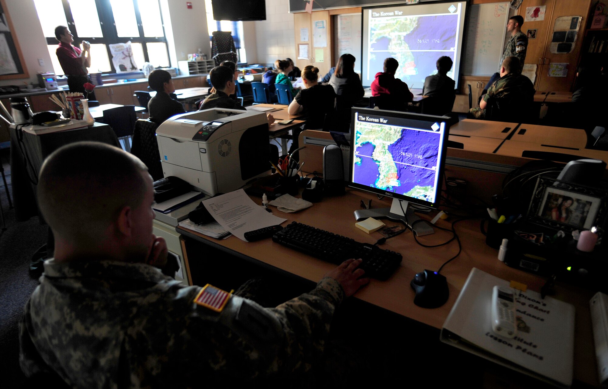 Army Cpl. Charles Pearson operates a slideshow as Army Staff Sgt. James
Meisenheimer gives an 8th grade journalism class at Osan Middle School a
briefing on the history and operations of the joint security area and
demilitarized zone between North and South Korea Dec. 16.  Corporal Pearson and Sergeant Meisenheimer are security escorts for the United Nations Command Security Battalion-Joint Security Area. (U.S. Air Force photo/Staff Sgt. Brian Ferguson)

