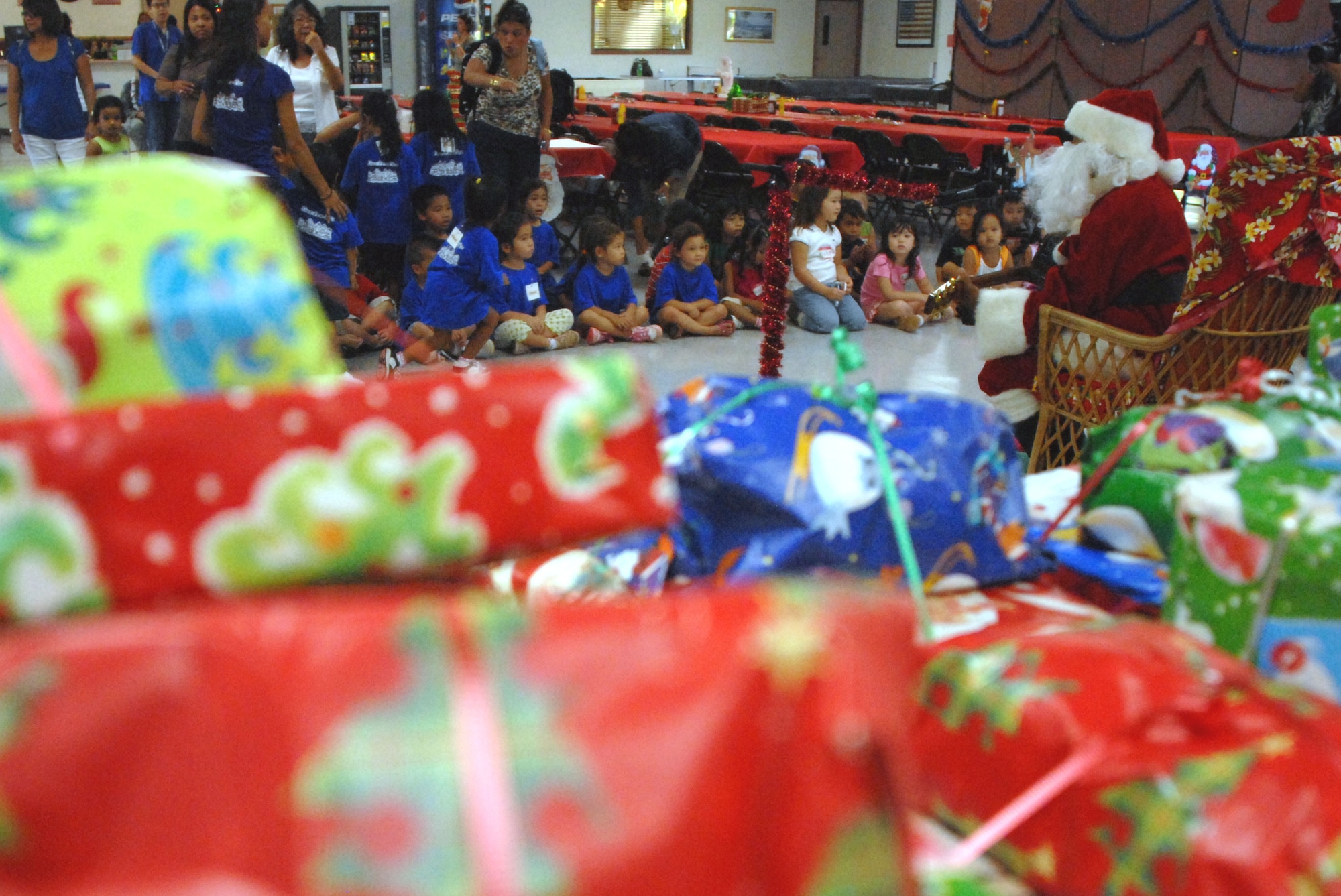 HICKAM AIR FORCE BASE, Hawaii - Ted Fabella, 15th Services Squadron, sings Christmas songs dressed as Santa Claus during the Head Start Holiday Party here, Dec. 17. The Annual event sponsored by the 15th Mission Support Group is held to support elementary school students with low income families. The event featured a movie, food, and gifts for the children donated by various organizations on base. (U.S. Air Force photo/Senior Airman Gustavo Gonzalez) 