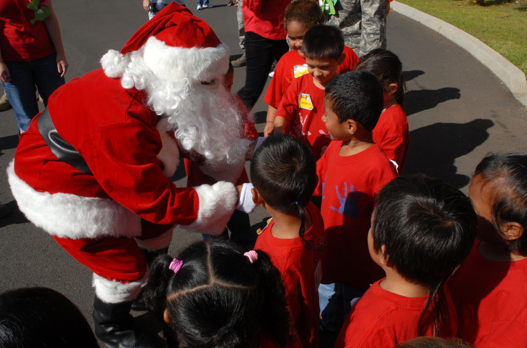 HICKAM AIR FORCE BASE, Hawaii - Ted Fabella, 15th Services Squadron, dressed as Santa Claus, greets children during the Head Start Holiday Party here, Dec. 17. The Annual event sponsored by the 15th Mission Support Group is held to support elementary school students with low income families. The event featured a movie, food, and gifts for the children donated by various organizations on base. (U.S. Air Force photo/Senior Airman Gustavo Gonzalez) 