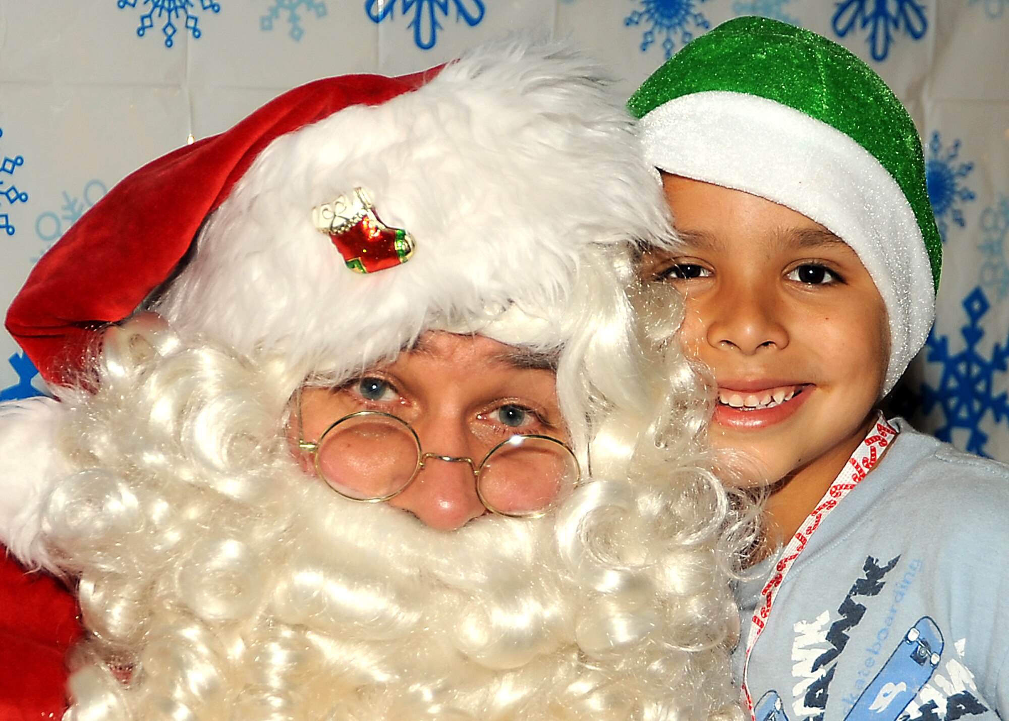 Mike Ibarra (age 7) poses for a picture with Santa during the “Candy Land” children’s holiday celebration at Fort MacArthur Hall, San Pedro, Calif., Dec. 12. Los Angeles Air Force Base’s Youth Programs provided food, fun and games for children ages 2-11. (Photo by Joe Juarez)