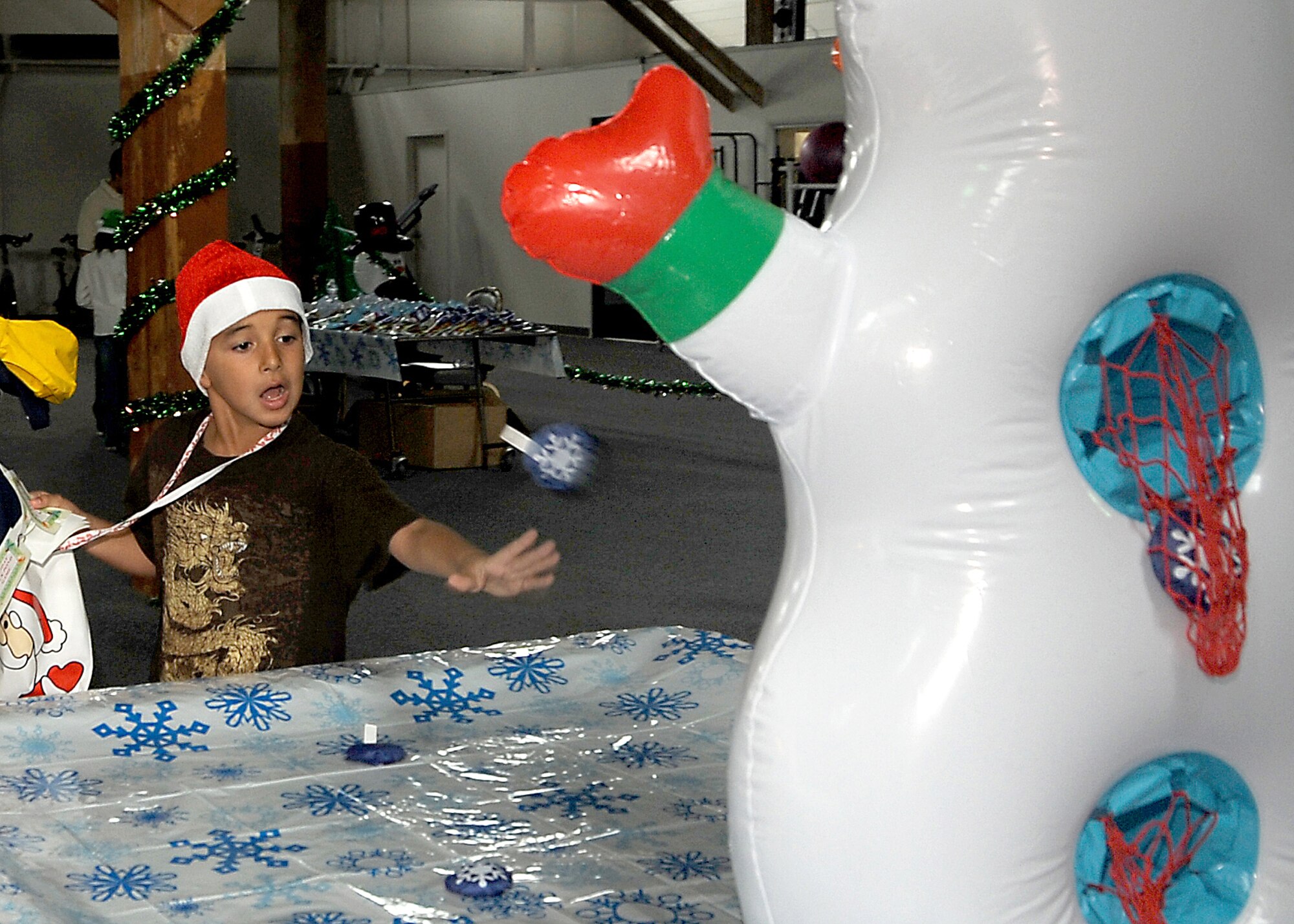 Ricardo Diaz takes a shot at Frosty for a prize at the “Candy Land” children’s holiday celebration at Fort MacArthur Hall, San Pedro, Calif., Dec. 12.  Los Angeles Air Force Base’s Youth Programs provided food, fun and games for children ages 2-11. (Photo by Joe Juarez)