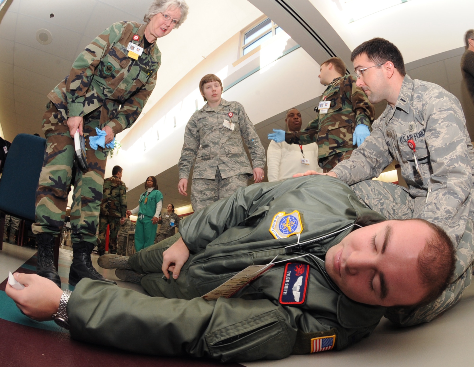 First Lt. Tyler Smith, 350th Air Refueling Squadron, simulates a seizure in the base clinic during a Major Accident Response Exercise, Dec. 15, 2009, at McConnell Air Force Base, Kan. The exercise simulated base water contamination and a hostage situation and prepared Airmen to deal with crisis situations for an upcoming Air Mobility Command Unit Compliance Inspection in February. (U.S. Air Force Photo/Airman 1st Class Ruiz)