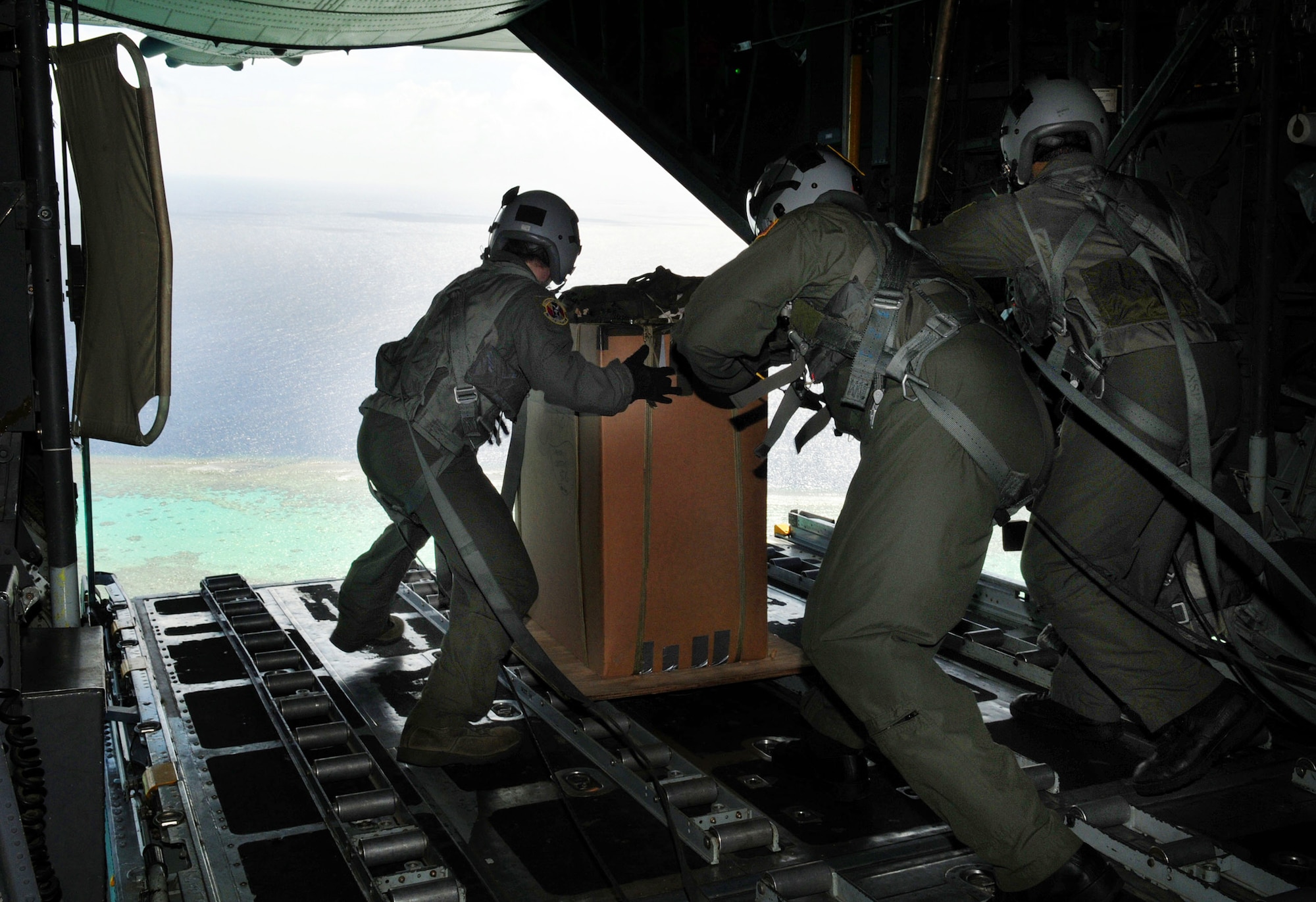 Airman from the 36th Airlift Squadron at Yokota Air Base, Japan, prepare to drop a package over a remote island near Chuuk Dec. 17, 2009. Operation Christmas Drop is a non-profit organization sponsored by volunteers from Andersen Air Force Base and the local Guam community. (U.S. Air Force photo/Airman 1st Class Courtney Witt)
