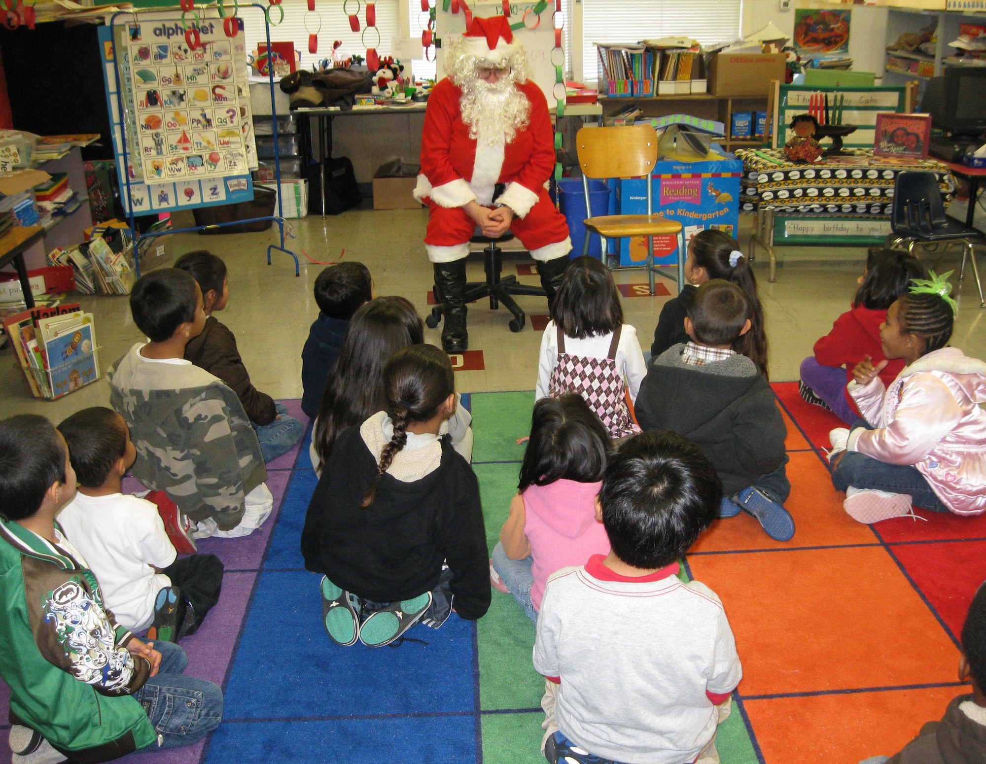 TRAVIS AIR FORCE BASE, Calif. -- Santa Claus (alias Technical Sgt. Dan Allen, 349th Medical Squadron) sings "Jingle Bells" with kindergarten children at Anna Kyle Elementary School in Fairfield, Calif., Dec. 14. Each year, for more than 25 years, the reservists from the 349th Air Mobility Wing have brought joy to local kindergarteners through Operation Teddy Bear. This community outreach project gathers and delivers teddy bears and gift bags to disadvantaged kindergarten children in local Title 1 schools. Sponsored by the wing Top Three Group, different squadrons each year share in the preparations and do the bulk of the work. This year, the 349th Medical Group was the lead unit. The 349th AMW Honor Guard also participates in the Operation Teddy Bear visits. (U.S. Air Force photo/Senior Master Sgt. Ellen L Hatfield).     