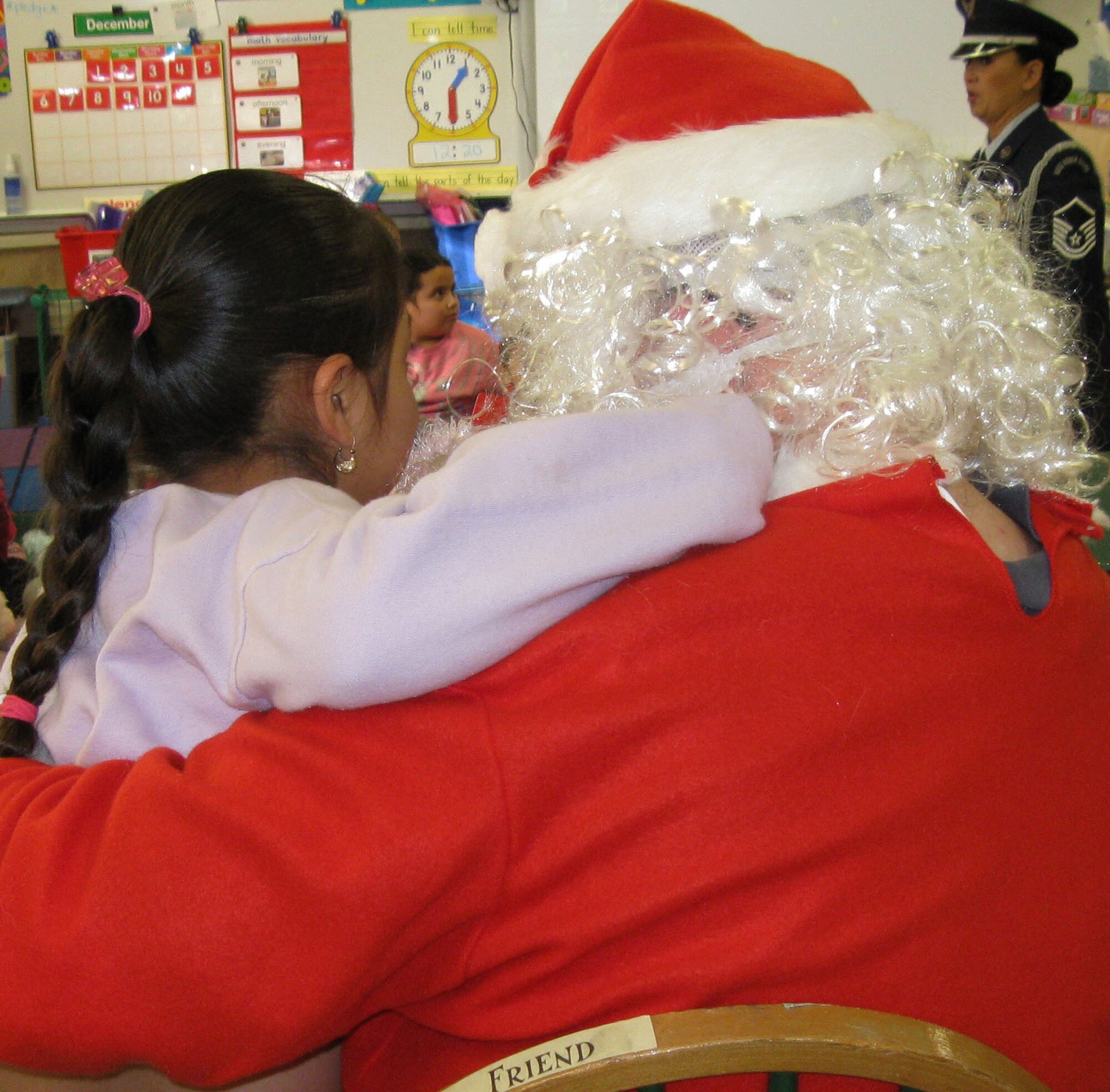 TRAVIS AIR FORCE BASE, Calif. -- Santa Claus (alias Technical Sgt. Dan Allen, 349th Medical Squadron) listens to the gift request of a kindergarten child at Anna Kyle Elementary School in Fairfield, Calif., Dec. 14. Each year, for more than 25 years, the reservists from the 349th Air Mobility Wing have brought joy to local kindergarteners through Operation Teddy Bear. This community outreach project gathers and delivers teddy bears and gift bags to disadvantaged kindergarten children in local Title 1 schools. Sponsored by the wing Top Three Group, different squadrons each year share in the preparations and do the bulk of the work. This year, the 349th Medical Group was the lead unit. The 349th AMW Honor Guard also participates in the Operation Teddy Bear visits. (U.S. Air Force photo/Senior Master Sgt. Ellen L Hatfield).     