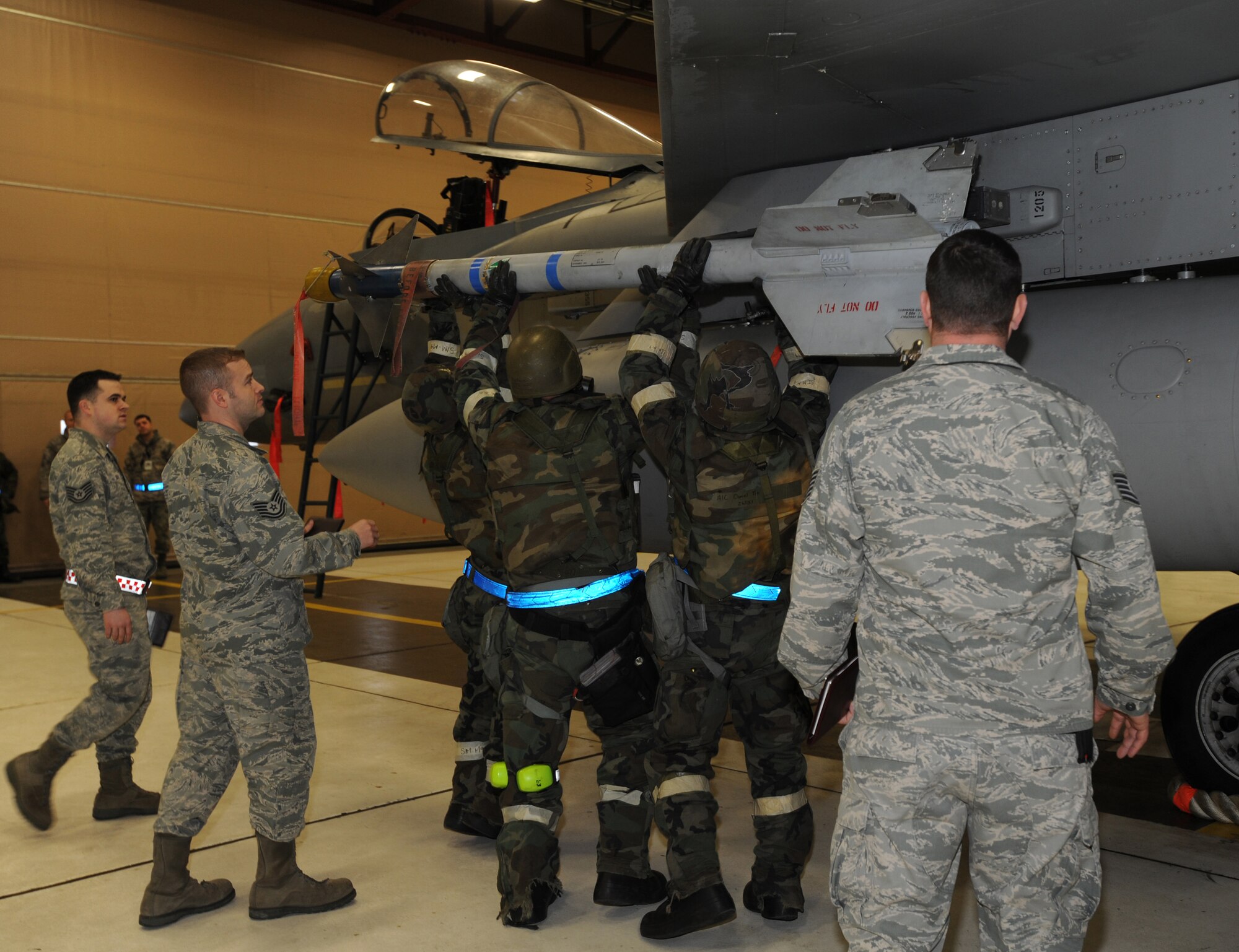 ELMENDORF AIR FORCE BASE, Alaska -- Airmen of the 19th Aircraft Maintenance Unit, upload an AIM-9 Missile onto an F-15 LAU-128 Missile Launcher on Dec. 11. The evaluators watched and ensured that the missile is loaded safely. (U.S. Air Force photo/Airman 1st Class Kristin High)