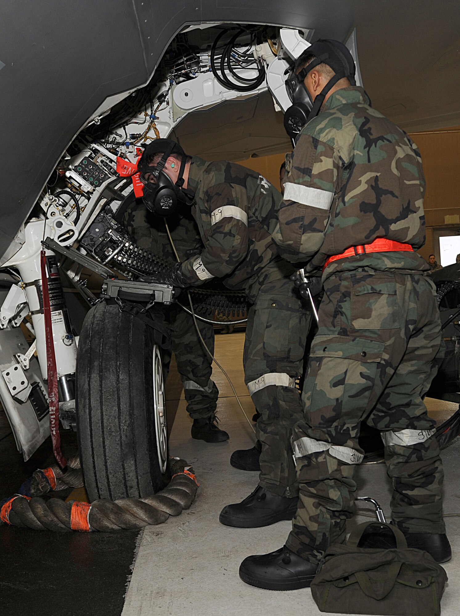 ELMENDORF AIR FORCE BASE, Alaska -- Airman 1st Class Bryan Ednave (right), 90th Aircraft Maintenance Unit, observes as Staff Sgt. Adam Ducharme, also of the 90th AMU, uses portable maintenance aid to follow technical data on the F-22 Raptor Dec. 11. The load crew competition was performed in Mission Oriented Protective Posture gear for the first time on Elmendorf AFB. (U.S. Air Force photo/Airman 1st Class Kristin High)