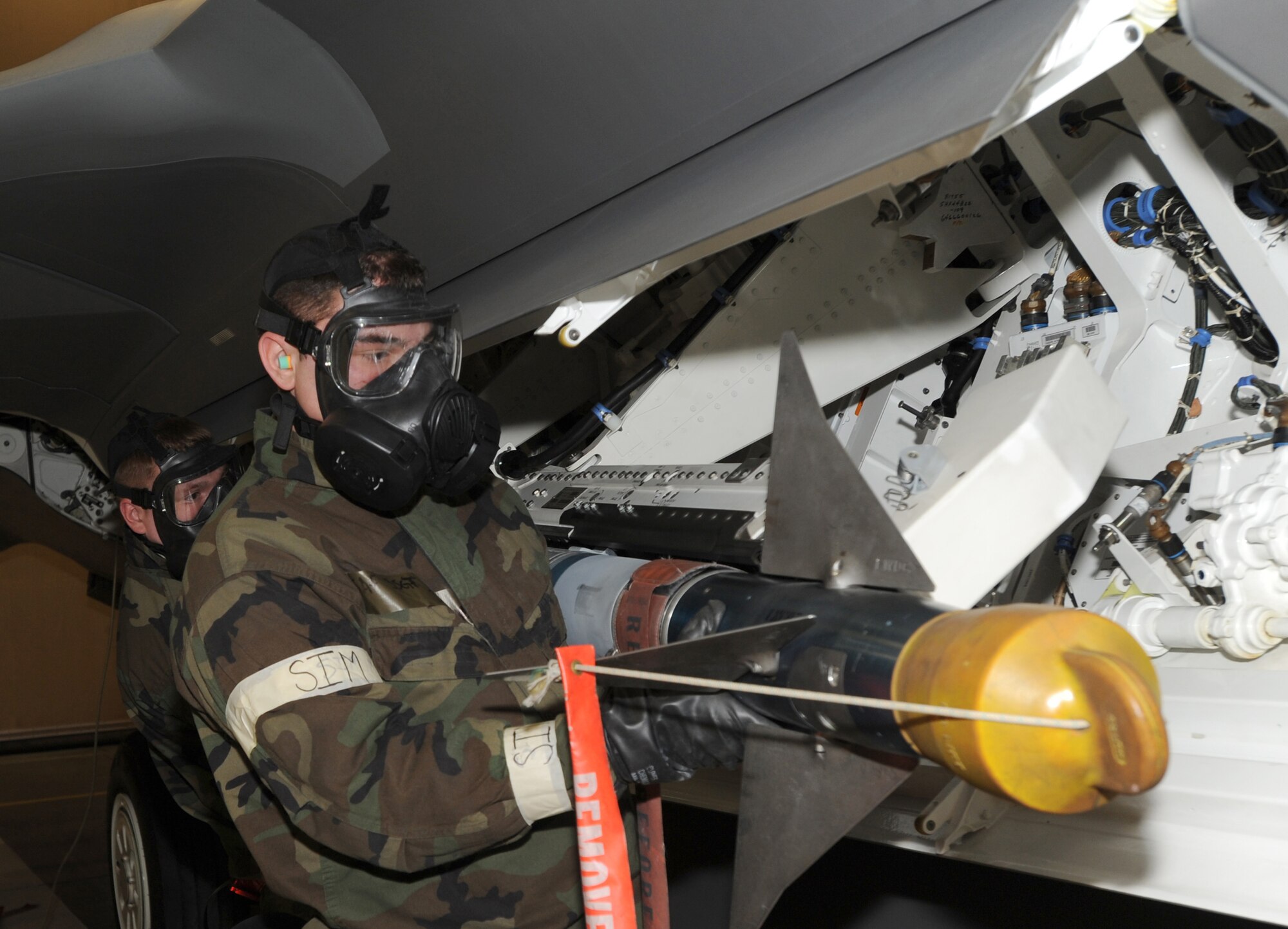 ELMENDORF AIR FORCE BASE, Alaska -- Staff Sgt. Adam Ducharme and Airman 1st Class Stephen Brady, 90th Aircraft Maintenance Unit, upload an AIM-9 Missile on an F-22 Raptor LAU-141 Missile Launcher Dec.11. The load crew competition was performed in Mission Oriented Protective Posture gear for the first time on Elmendorf AFB. (U.S. Air Force photo/Airman 1st Class Kristin High)