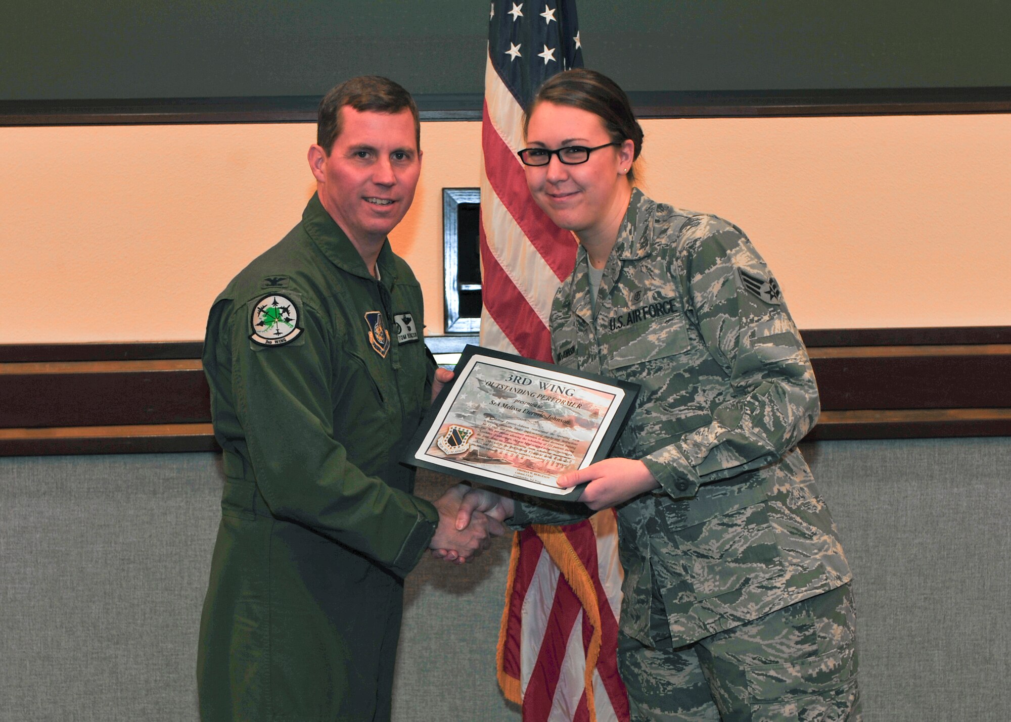 Senior Airman Melissa Eterovic-Johnson, 3rd Surgical Operations Squadron, receives a 3rd Wing outstanding performer certificate from Col. Thomas Bergeson, 3rd Wing commander Dec. 15. (U.S. Air Force photo/Senior Airman Tinese Jackson)
