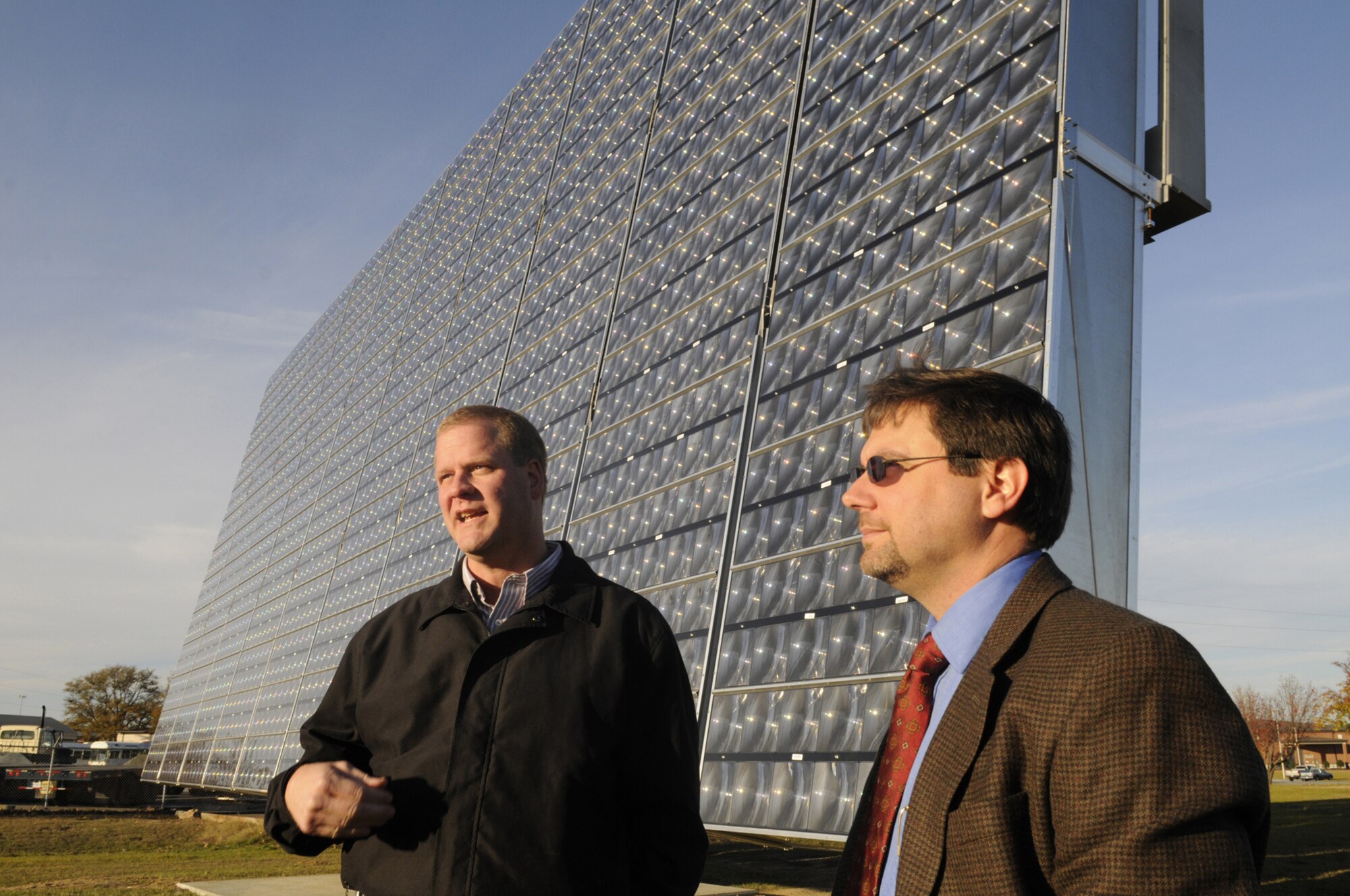 Scott Slyfield and Robert David talk about the APTO 25kW Tracking Solar Array. U. S. Air Force photo by Sue Sapp